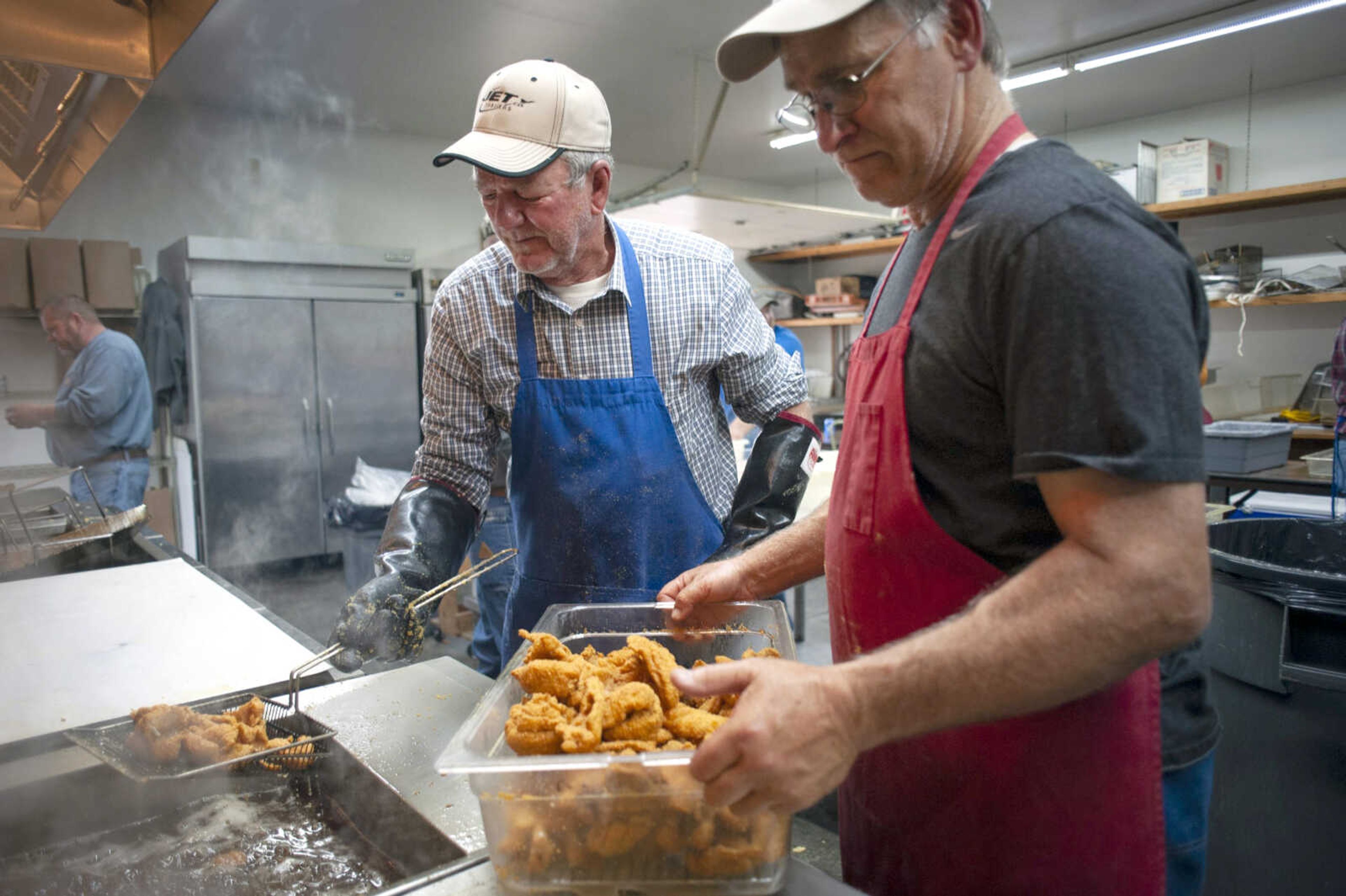 Otto Kern takes fish out of the fryer with the help of Tom Essner, both Knights of Columbus of New Hamburg, Missouri, during a fish fry Friday at Scott City Knights of Columbus. David Glastetter, a Knight of Columbus originally from Kelso, Missouri, and now of Cape Girardeau, said the fish fries have been taking place at the location since the late 1980s.