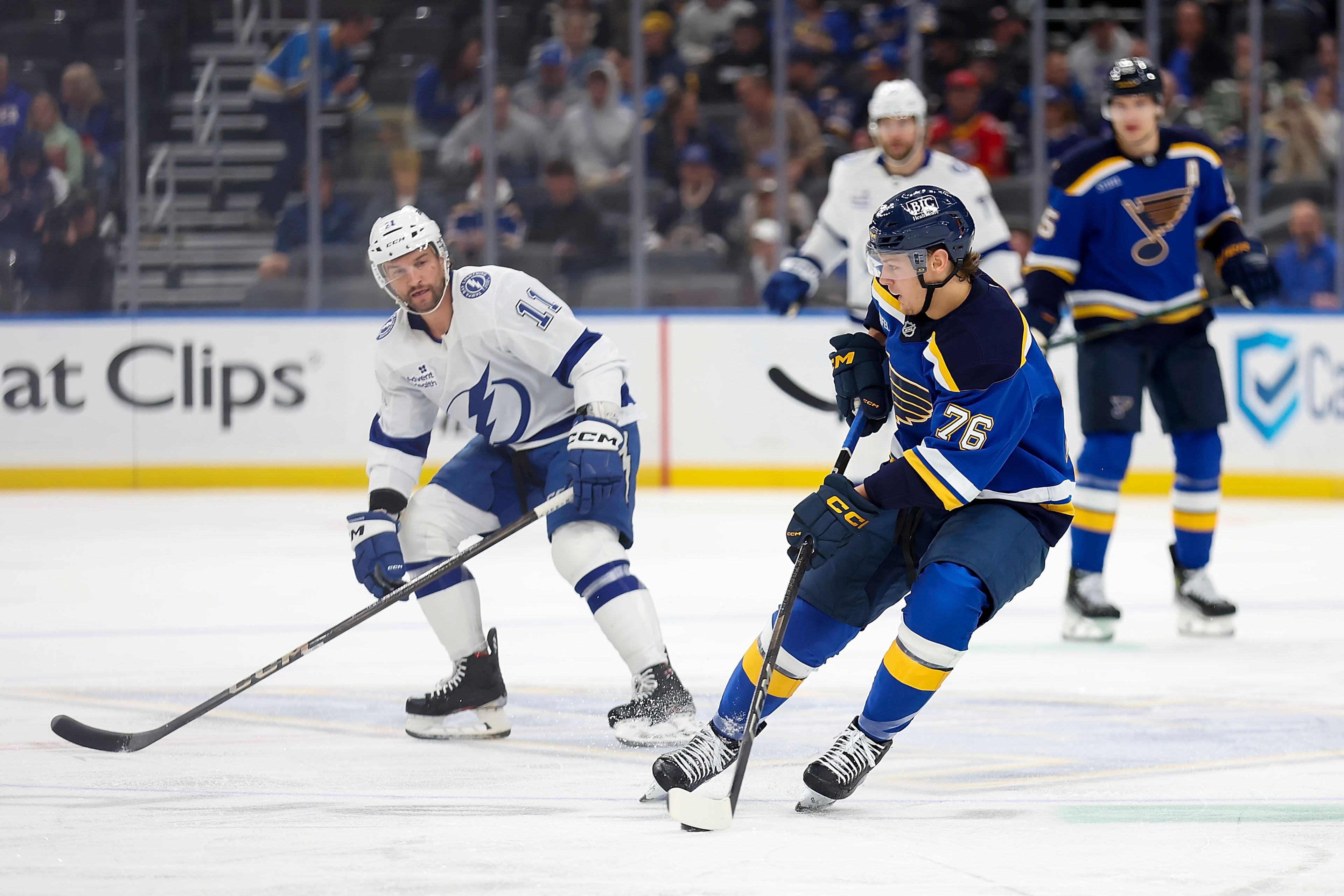 St. Louis Blues' Zack Bolduc (76) controls the puck in front of Tampa Bay Lightning's Luke Glendening (11) during the first period of an NHL hockey game Tuesday, Nov. 5, 2024, in St. Louis. (AP Photo/Scott Kane)