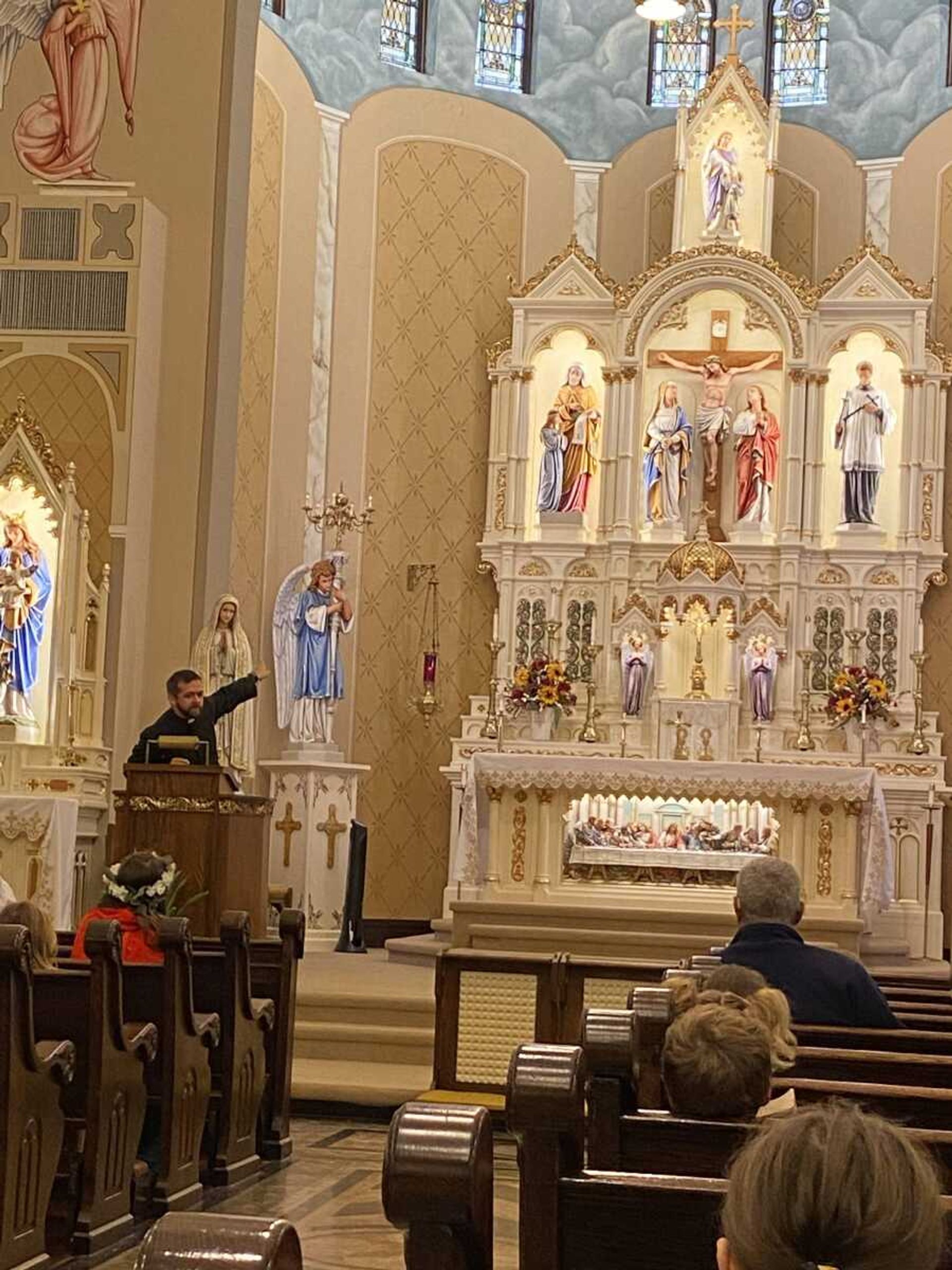 Father Joseph Kelly explains who each Saint statue in church is to the students and staff of Guardian Angel School.
