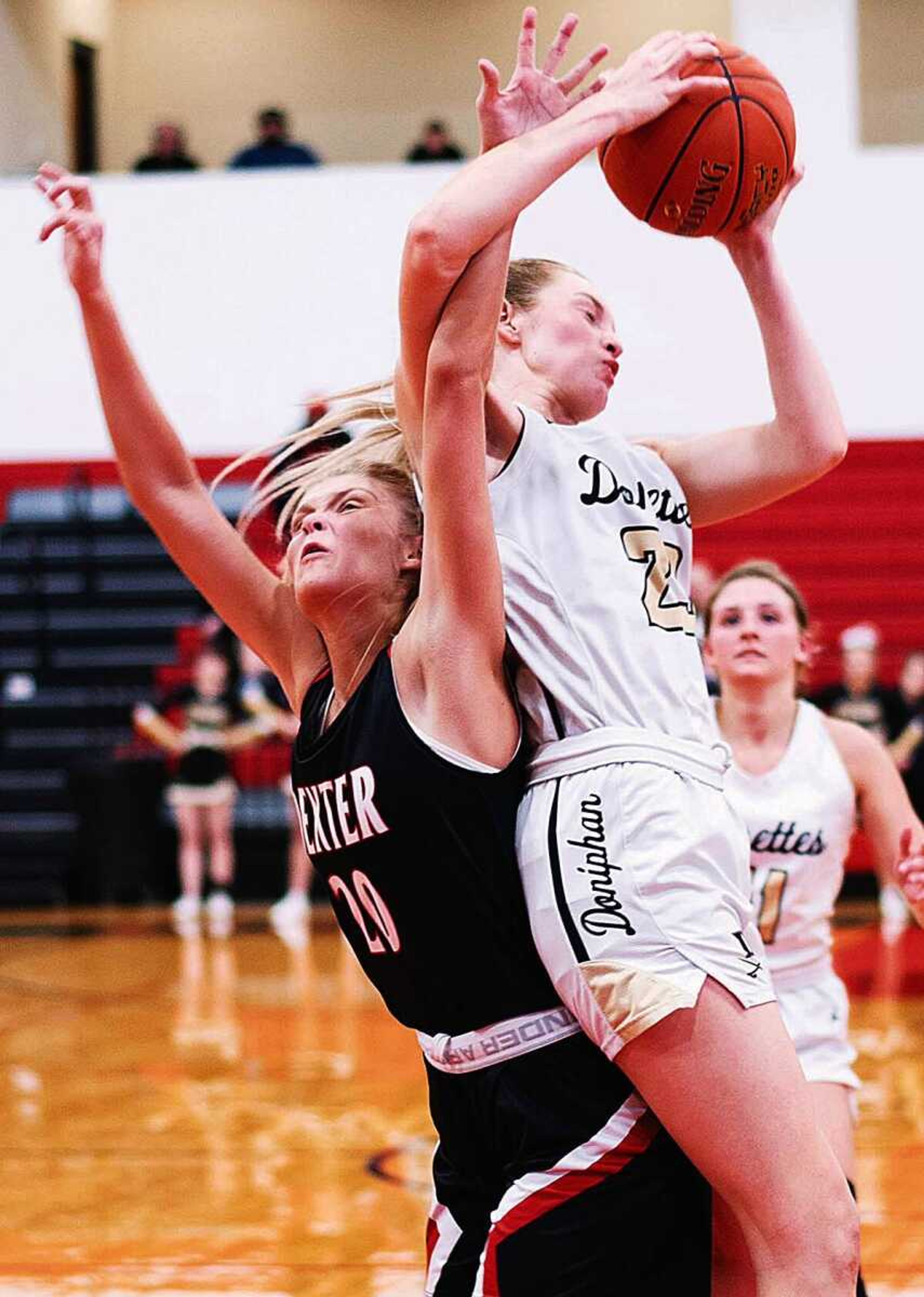 Doniphan�s Sarah Owen (right) lands on the back of Dexter�s Caitlin Giles during Thursday�s MSHSAA Class 4 District 1 girls basketball semifinal action in Dexter.