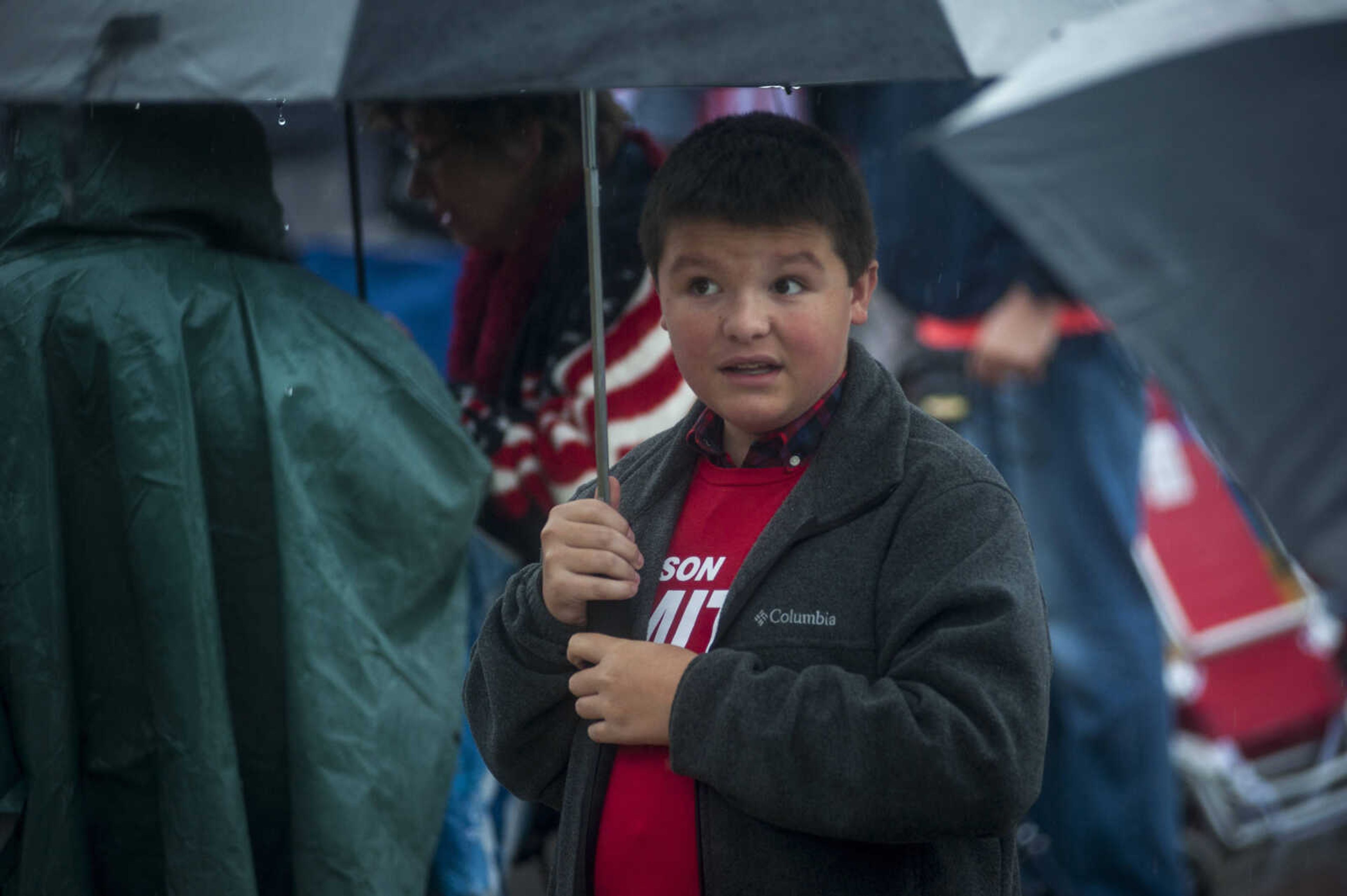 Luke Tanner, 13, of Sikeston, Missouri, stands with an umbrella in the rain outside of the Show Me Center Monday, Nov. 5, 2018, in Cape Girardeau. "What people don't get is that our president is awesome and people need to support him," Tanner said. "He needs it."