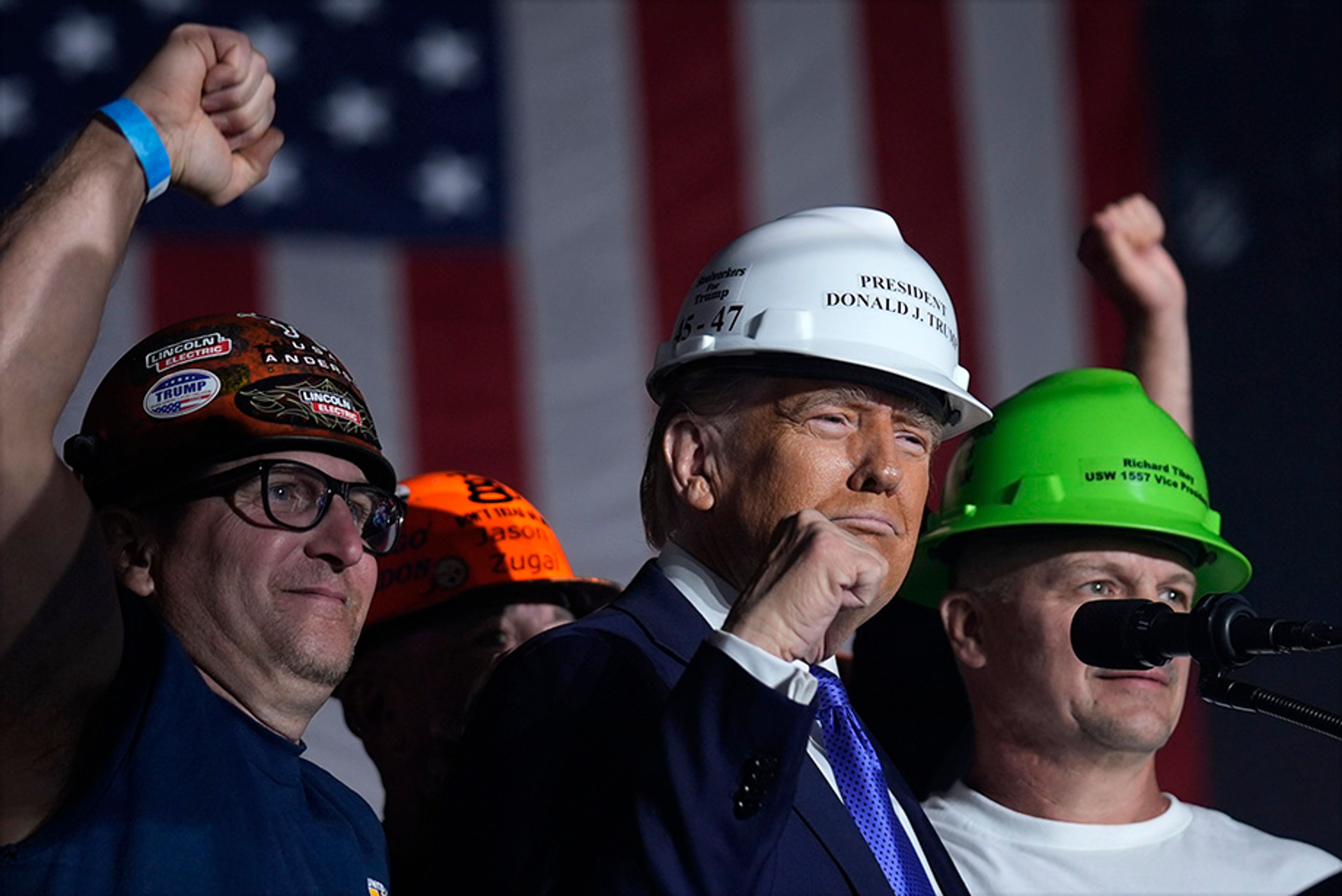 Republican presidential nominee former President Donald Trump stands on stage with steelworkers as he speaks during a campaign rally at Arnold Palmer Regional Airport, Saturday, Oct. 19, 2024, in Latrobe, Pa. 