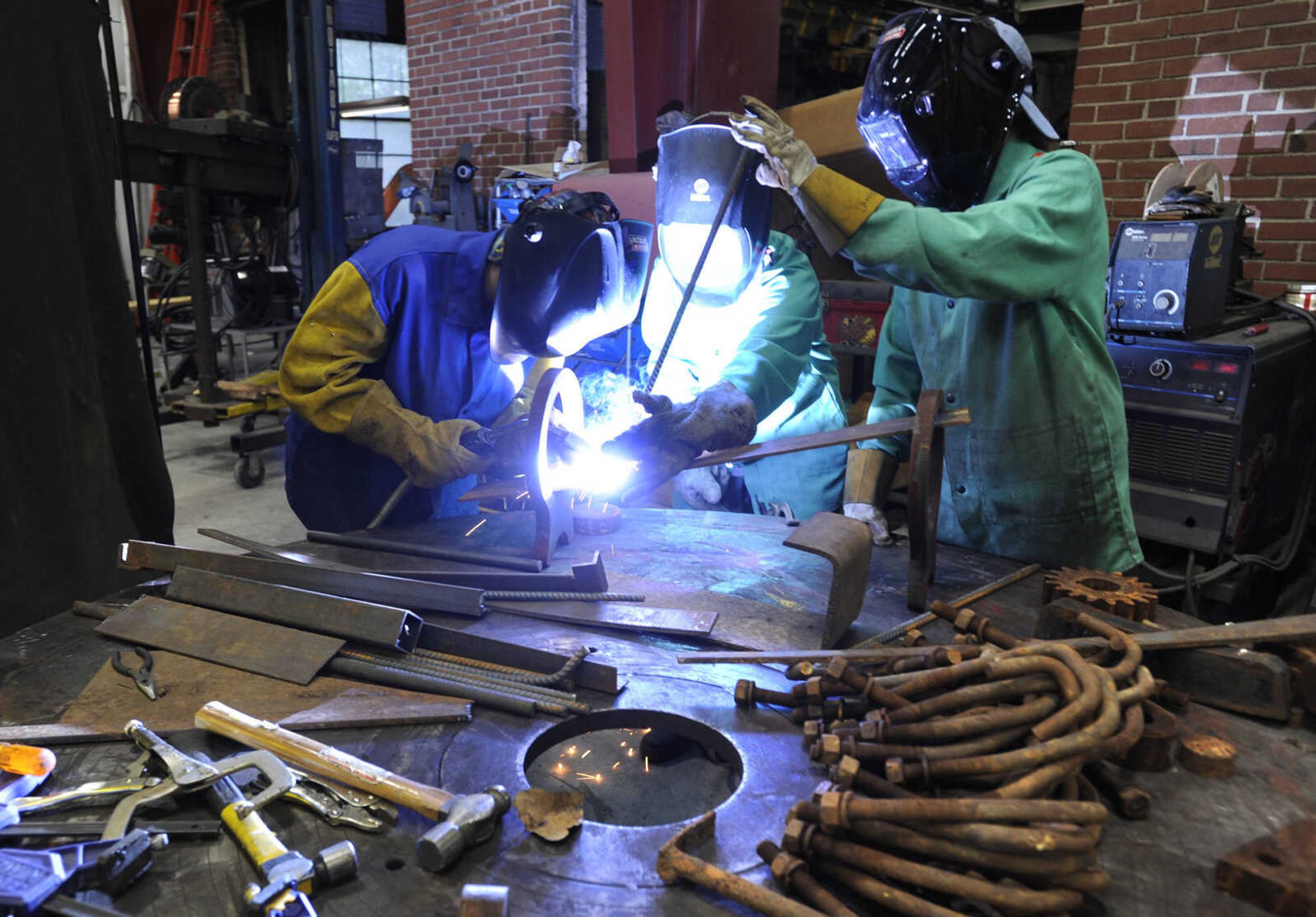 FRED LYNCH ~ flynch@semissourian.com
Deanna Hoffman, left, Jessica Lambert and Brigit Ciskowski work on a collaborative steel sculpture Thursday, April 20, 2017 during ARTrageous at Erlbacher Gear and Machine Works in Cape Girardeau.