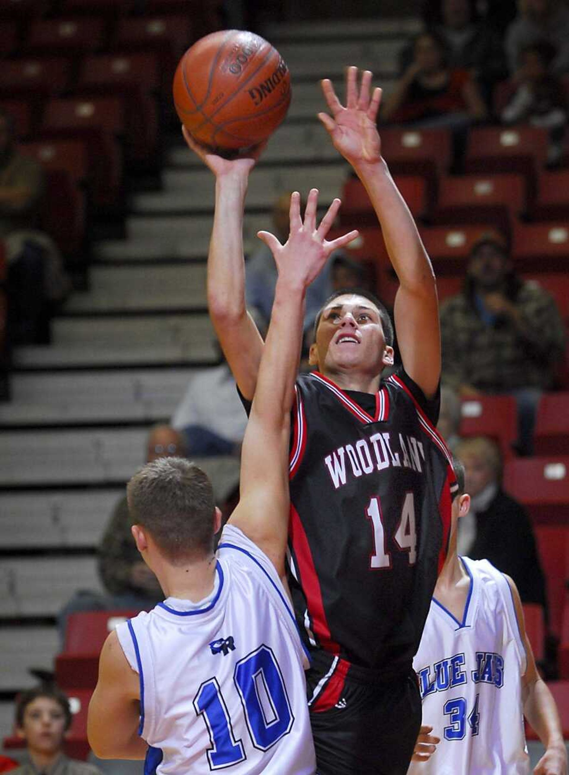 Woodland's Joe Layton took a shot over Oak Ridge's Dylan Abbott in overtime during Thursday's consolation semifinal game. Oak Ridge won 70-65. (Fred Lynch)