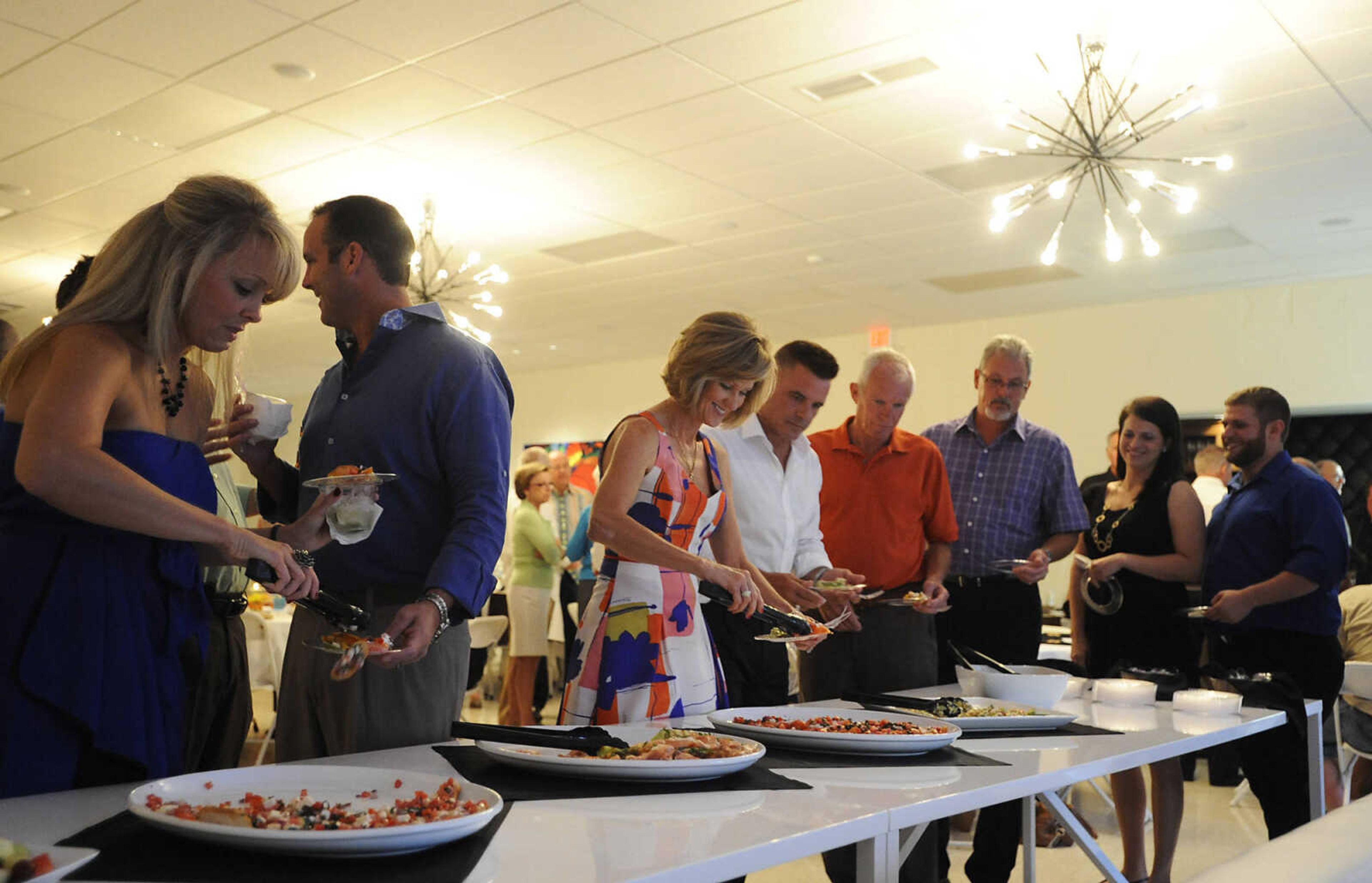 Attendees fill their plates at The Summer Cocktail Soiree Friday, Aug. 3, at the Concourse, 429 N. Broadview St. in Cape Girardeau. A fundraiser for Levi's Adventure Trail, an exhibit at the Discovery Playhouse in Cape Girardeau, the event featured live music, a silent auction and gourmet appetizers. The exhibit is named after Levi Stephen Collom, who died at age 3 earlier this year.