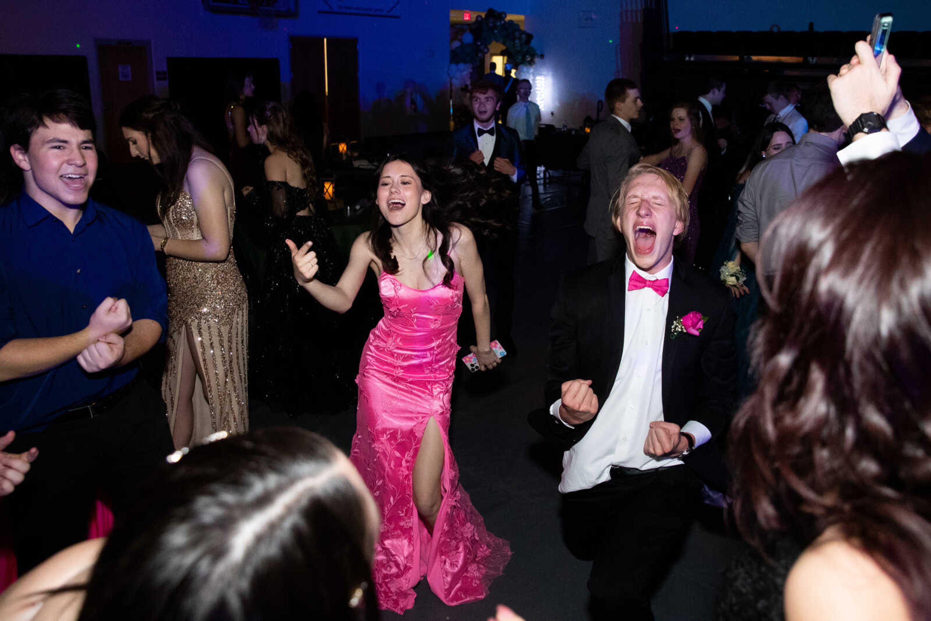 Benjamin Coffee and Sarah Niswonger sing passionately as they dance with their friends at prom on Saturday, May 6 at Jackson High School.