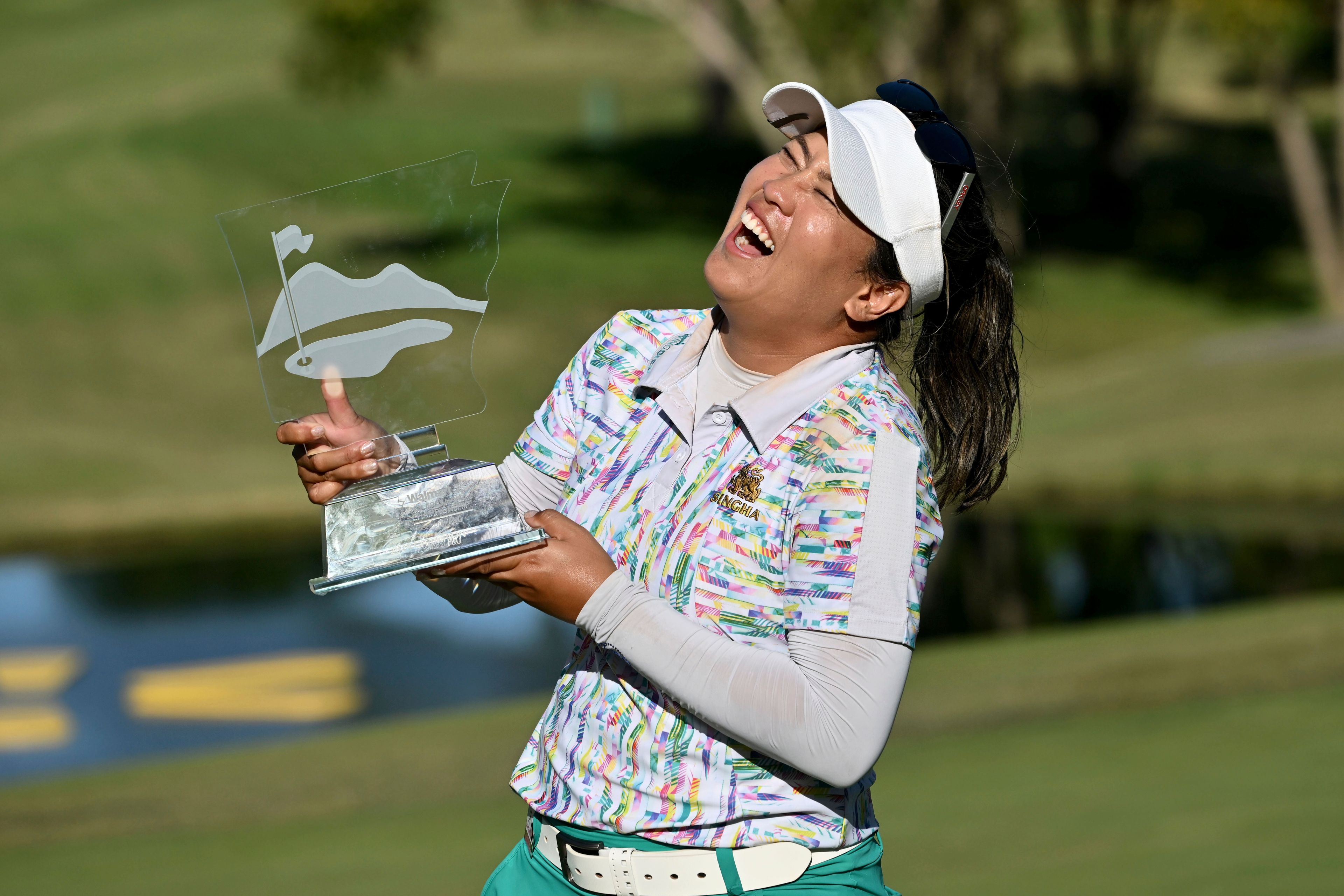 Jasmine Suwannapura, of Thailand, celebrates with her trophy after winning the LPGA Walmart NW Arkansas Championship golf tournament, Sunday, Sept. 29, 2024, in Rogers, Ark. (AP Photo/Michael Woods)