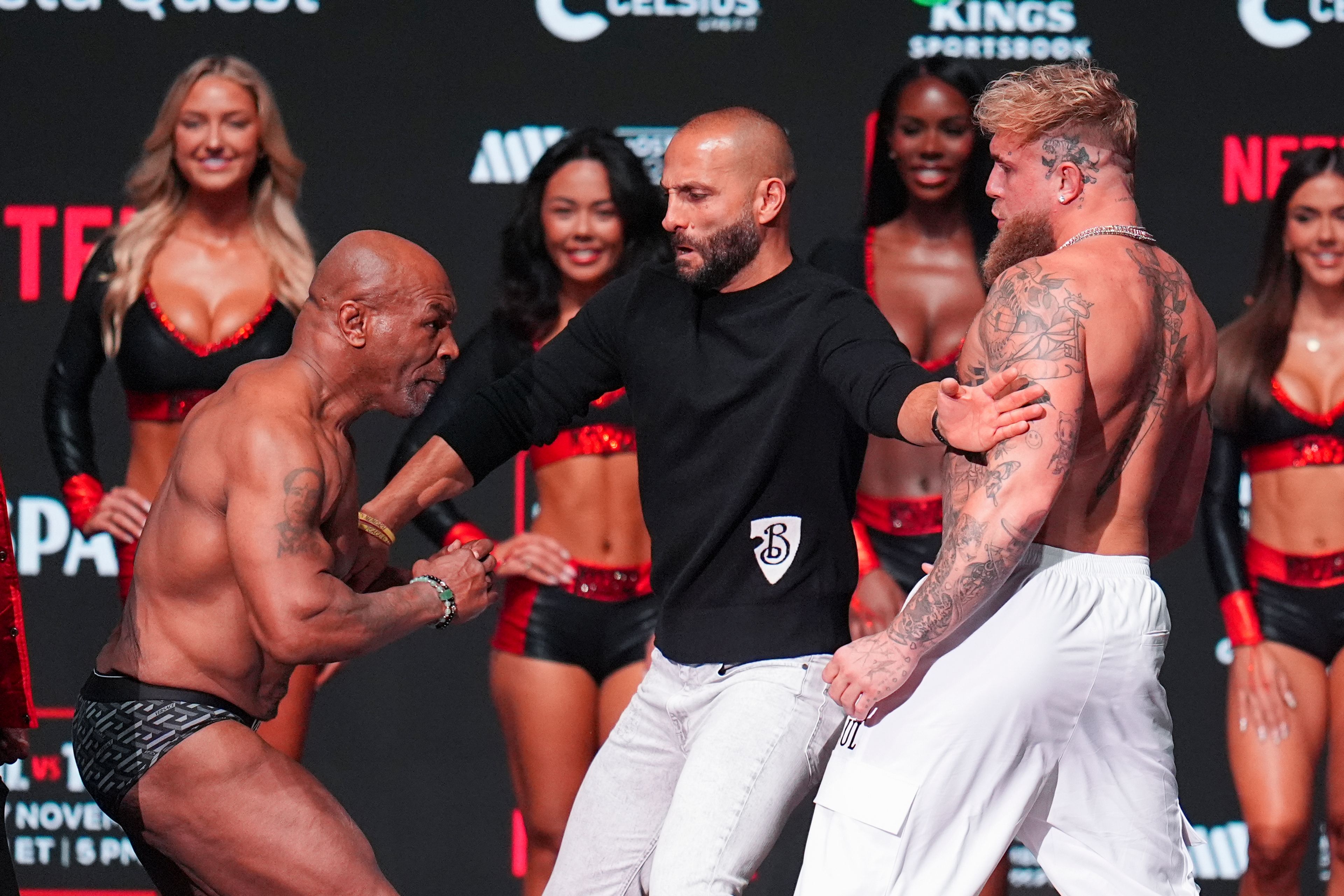 Promoter Nakisa Bidarian, center, co-founder of Most Valuable Promotions, steps in the way of Mike Tyson, left, after Tyson slapped Jake Paul during a weigh-in ahead of their heavyweight bout, Thursday, Nov. 14, 2024, in Irving, Texas. (AP Photo/Julio Cortez)