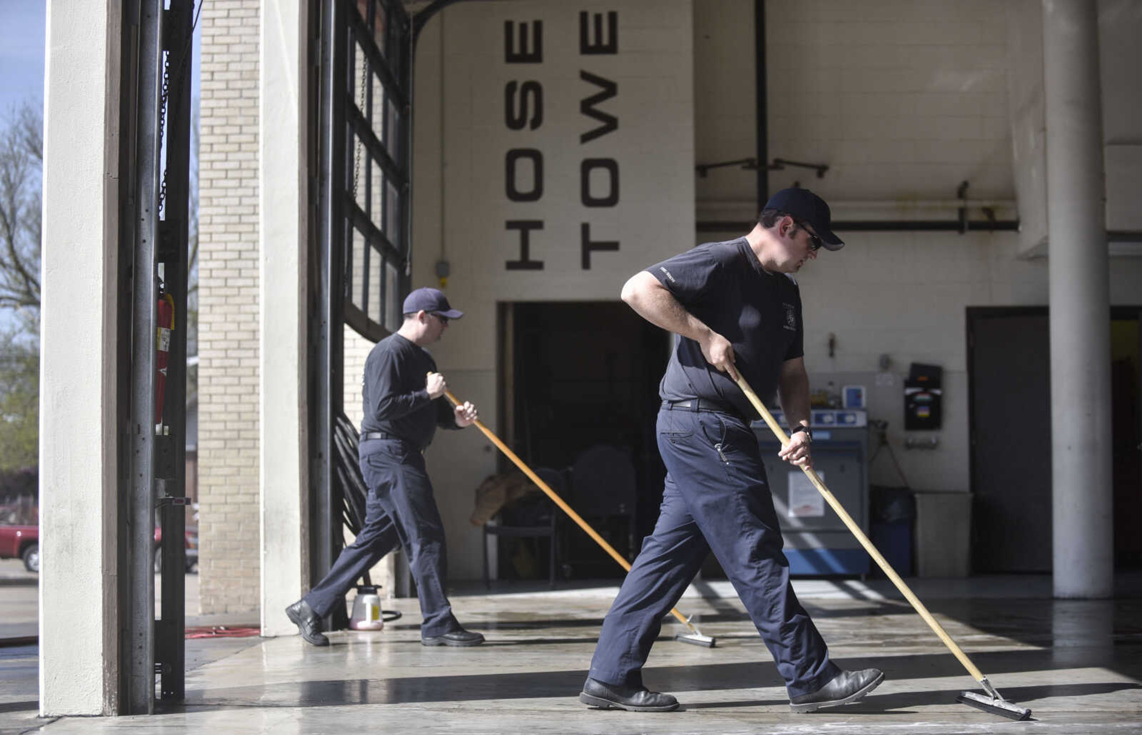 From left, Cape Girardeau fire captain Shawn Morris and firefighter Justin Siemers squeegee the garage floor of Cape Girardeau Fire Station No. 1 on Tuesday, April 17, 2018, in Cape Girardeau.