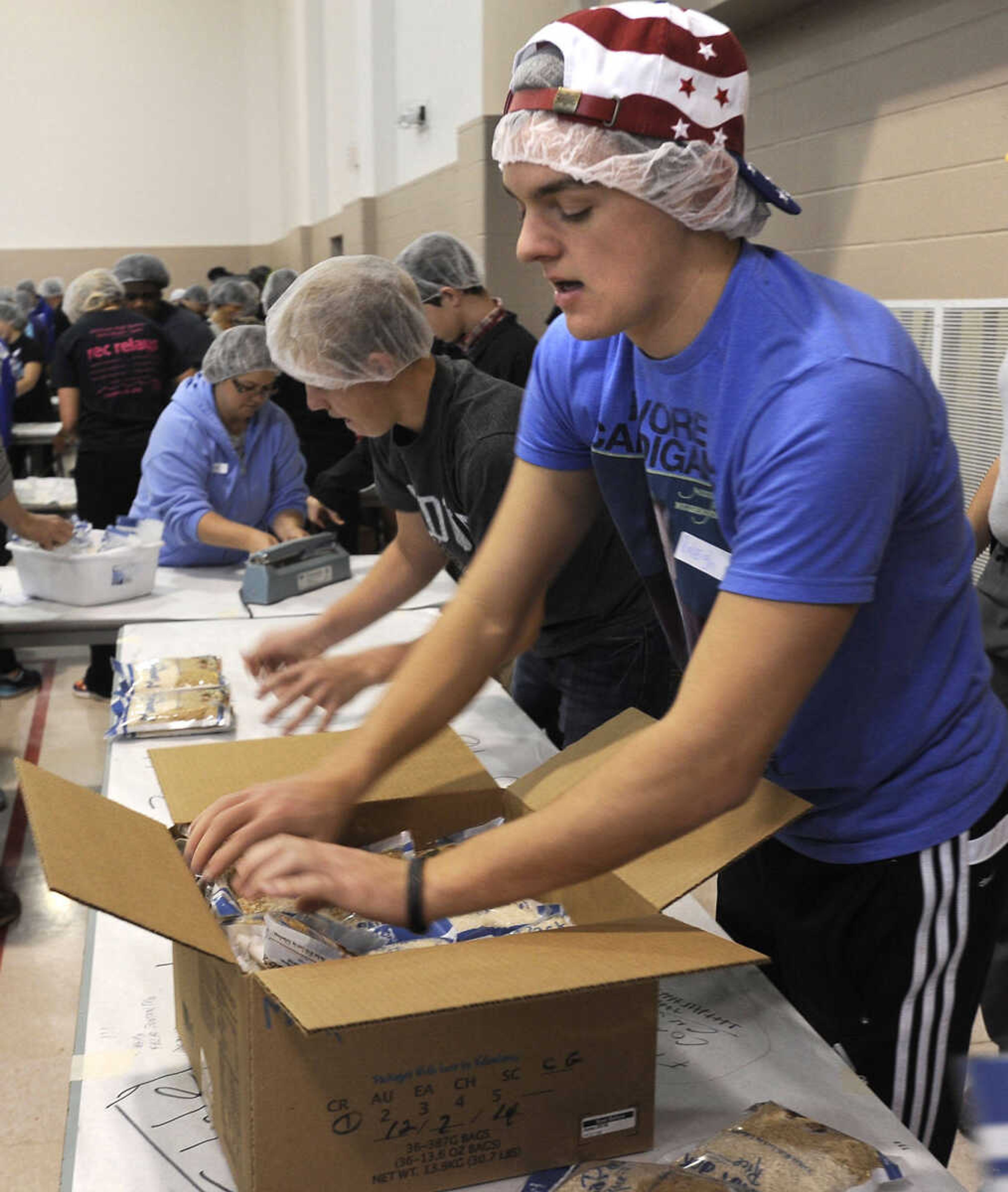 Raleigh Davis packs rice bags into boxes for shipping at the Feed My Starving Children MobilePack event Sunday, Dec. 7, 2014 at the Osage Centre in Cape Girardeau.