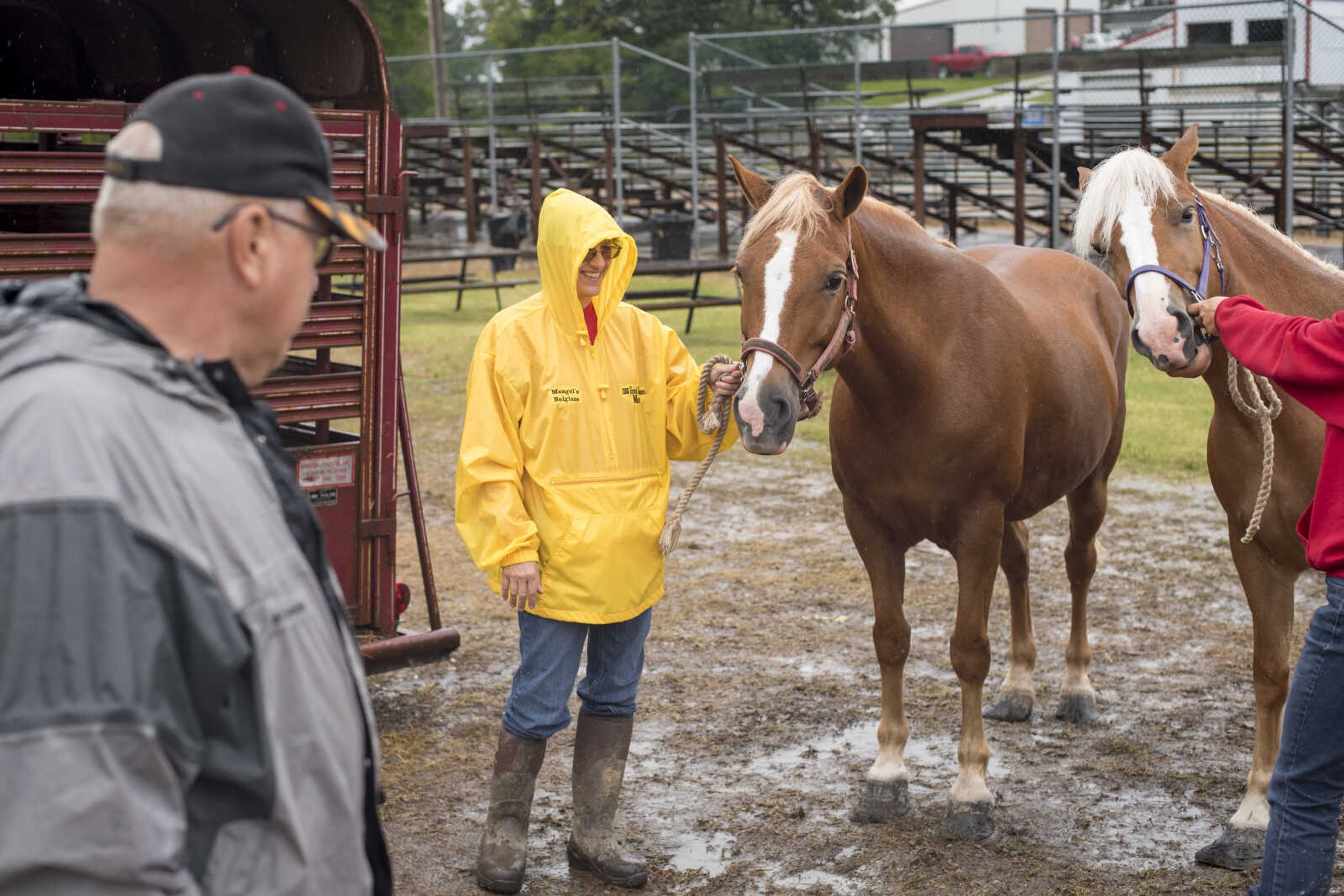 Sandy Mangels (yellow jacket) shows her horse, Bubbles, as a drizzle comes down on the East Perry County Fair Saturday. Mangels and her sister, Darla, (red jacket, not pictured) jointly won second place for their pair of horses.