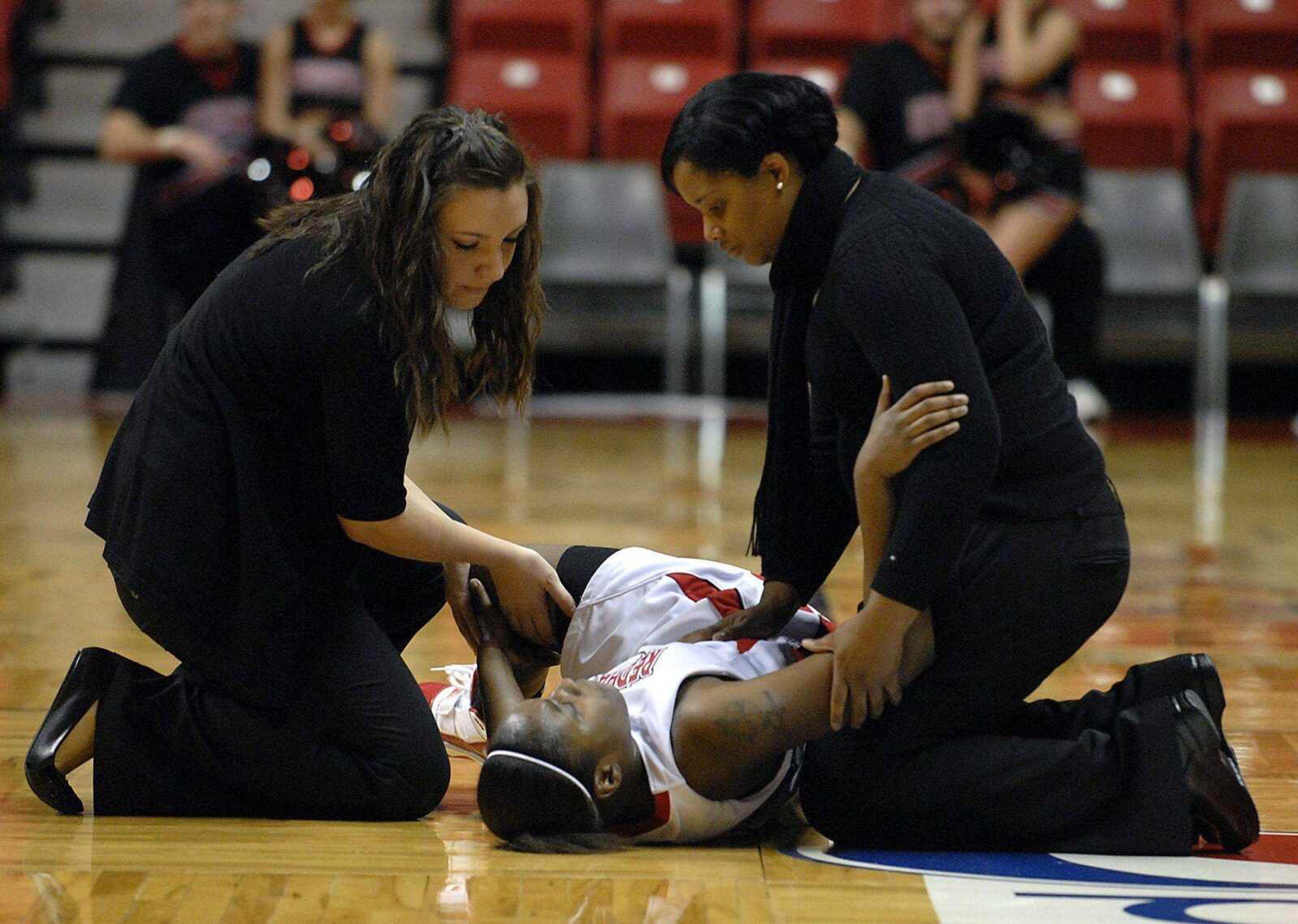 Trainers assist freshman Jasmine Davis during Monday's game at the Show Me Center. Davis was injured on a hard foul in the final minute of play and will miss the remainder of the season. (Kit Doyle)