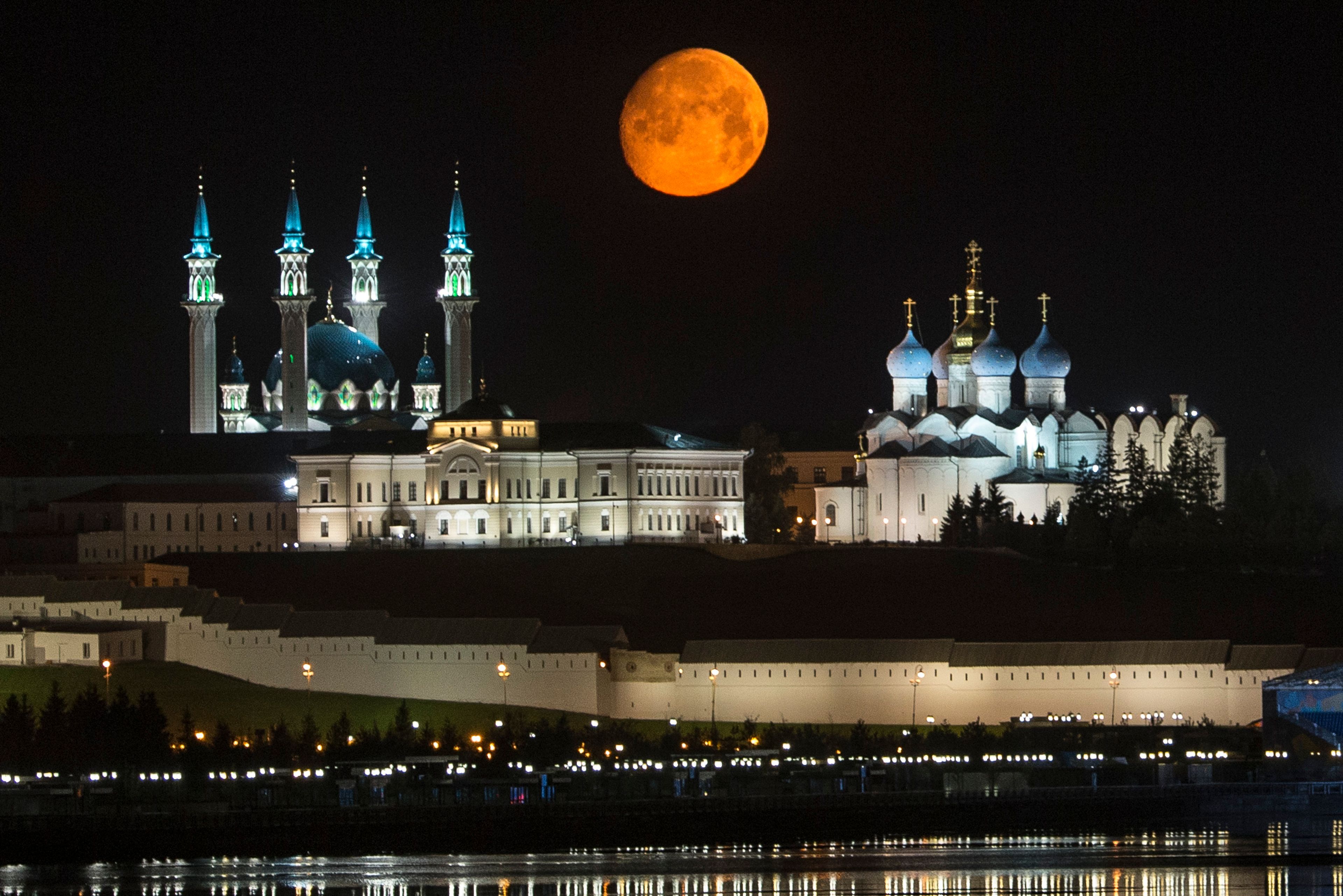 FILE - The full moon rises over the Kazan Kremlin with the Qol Sharif mosque, left, and the Cathedral of the Transfiguration, right, in Kazan, Russia, about 700 km (450 miles) east of Moscow, on July, 29, 2015. (AP Photo/Denis Tyrin, File)