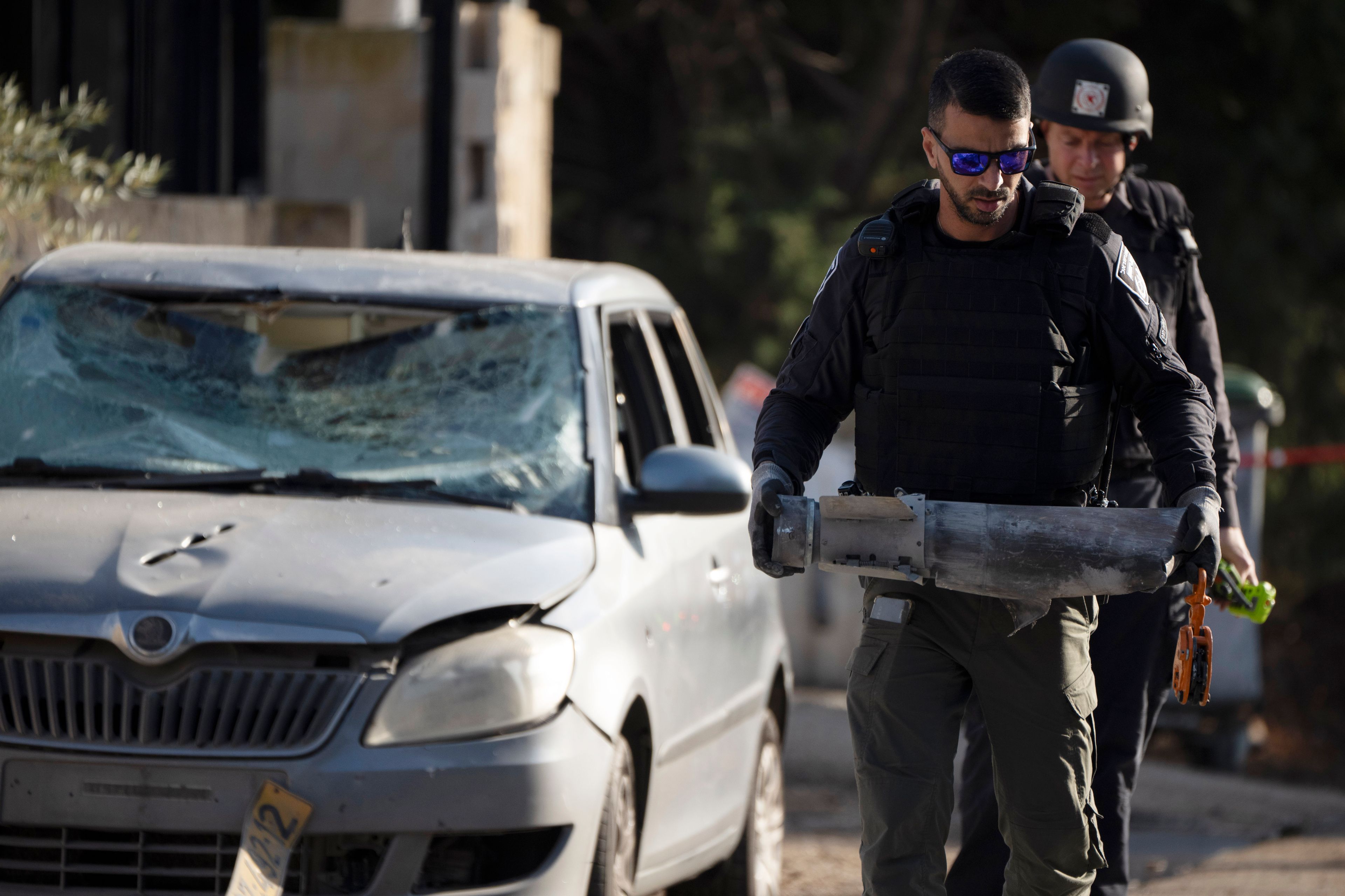 A member of the Israeli security forces carries a piece of a projectile extracted from the site where a rocket, fired from Lebanon, hit an area in the town of Nahariya, northern Israel, Thursday, Nov. 21, 2024. (AP Photo/Leo Correa)