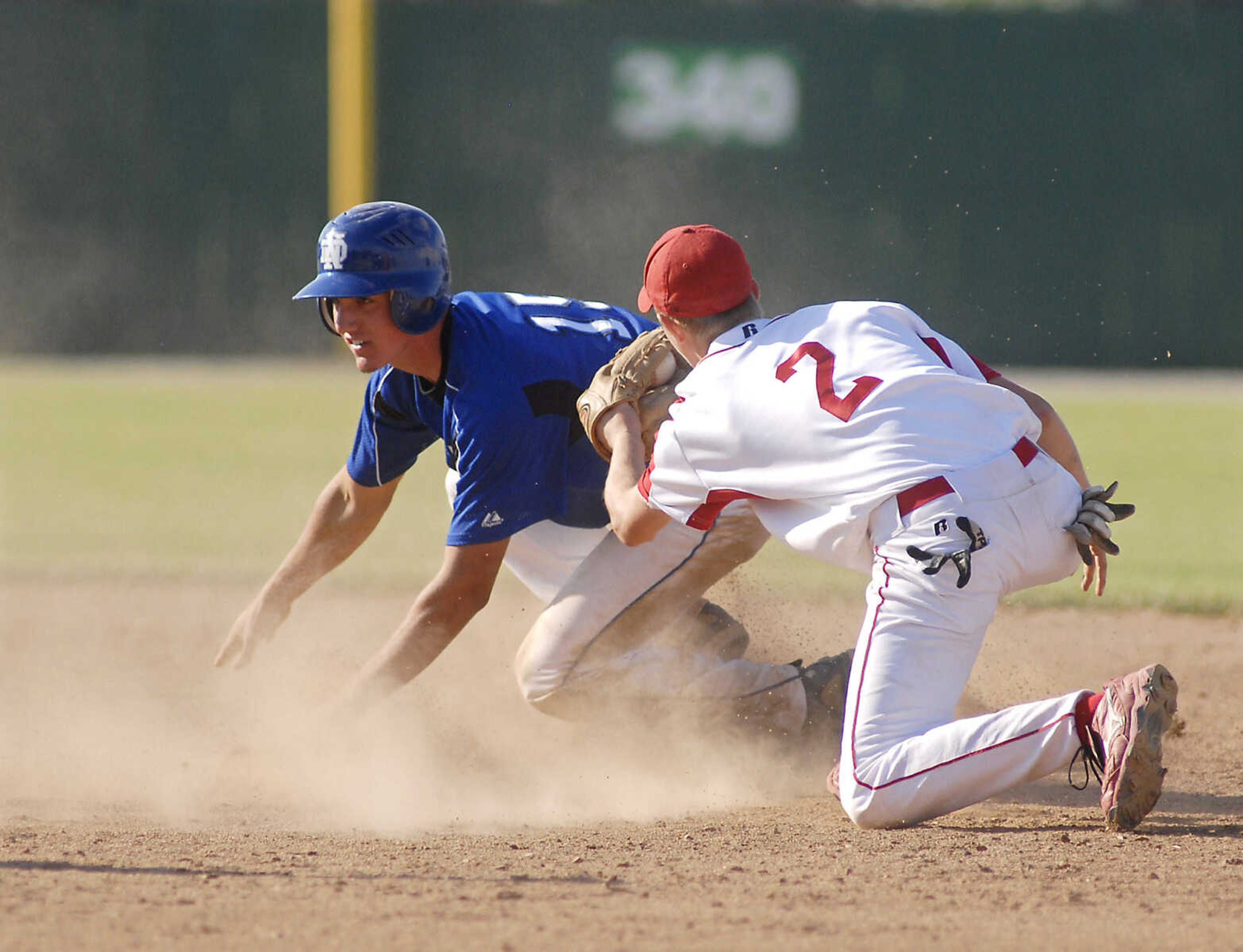 JUSTIN KELLEY photo
Notre Dame's Mark Glastetter waits for the call after sliding safely into first base around the tag of Carl Junction's Logan Deem during the Class 3 championship game Saturday, June, 6 2009, at Meador Park in Springfield.