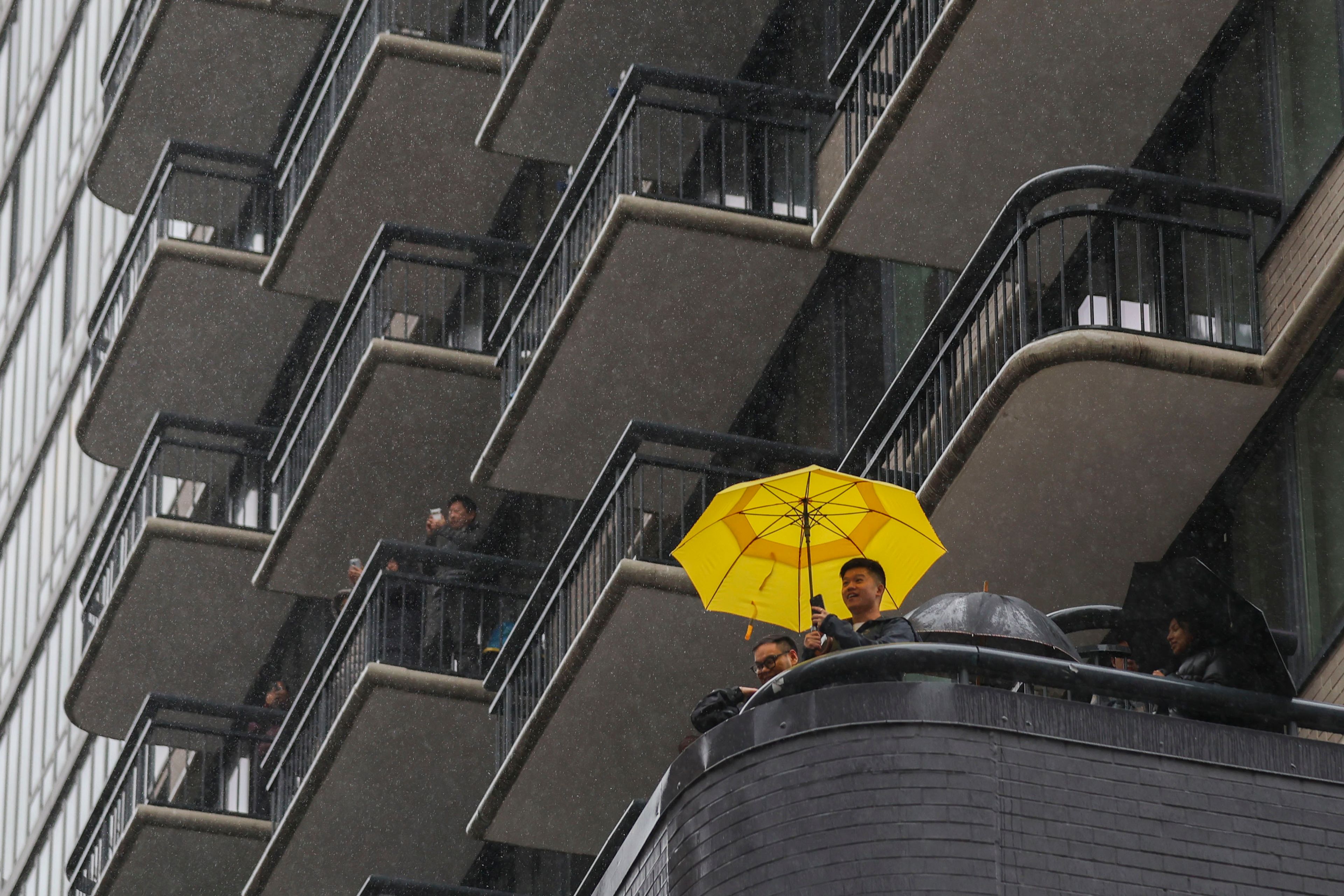 People watch from their balconies above during the Macy's Thanksgiving Day Parade, Thursday, Nov. 28, 2024, in New York. (AP Photo/Heather Khalifa)