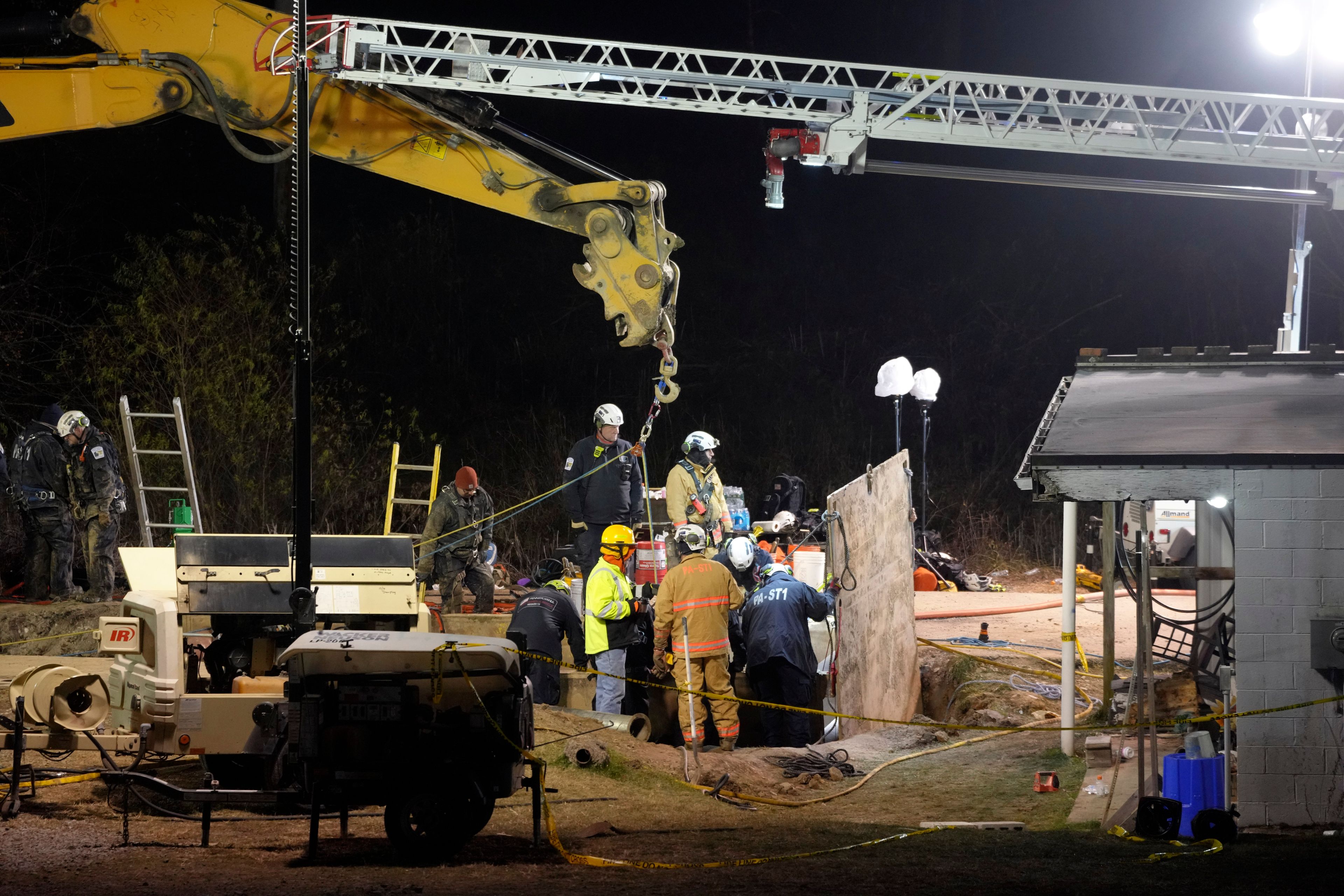 Rescue workers search through the night in a sinkhole for Elizabeth Pollard, who disappeared while looking for her cat, in Marguerite, Pa., Tuesday, Dec. 3, 2024. (AP Photo/Gene J. Puskar)