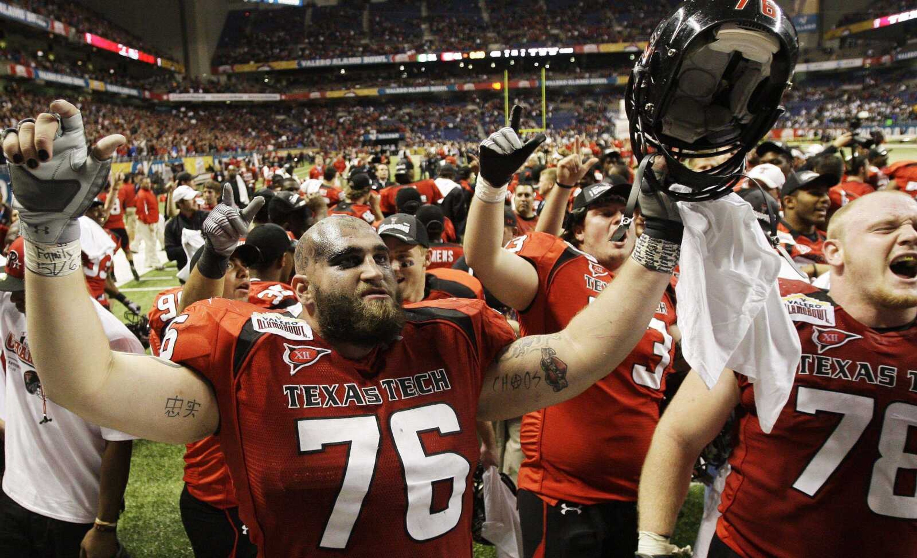 Texas Tech's Brandon Carter (76) and Lonnie Edwards (78) celebrate with teammates Saturday after they defeated Michigan State in the Alamo Bowl in San Antonio. Texas Tech won 41-31. (ERIC GAY ~ Associated Press)