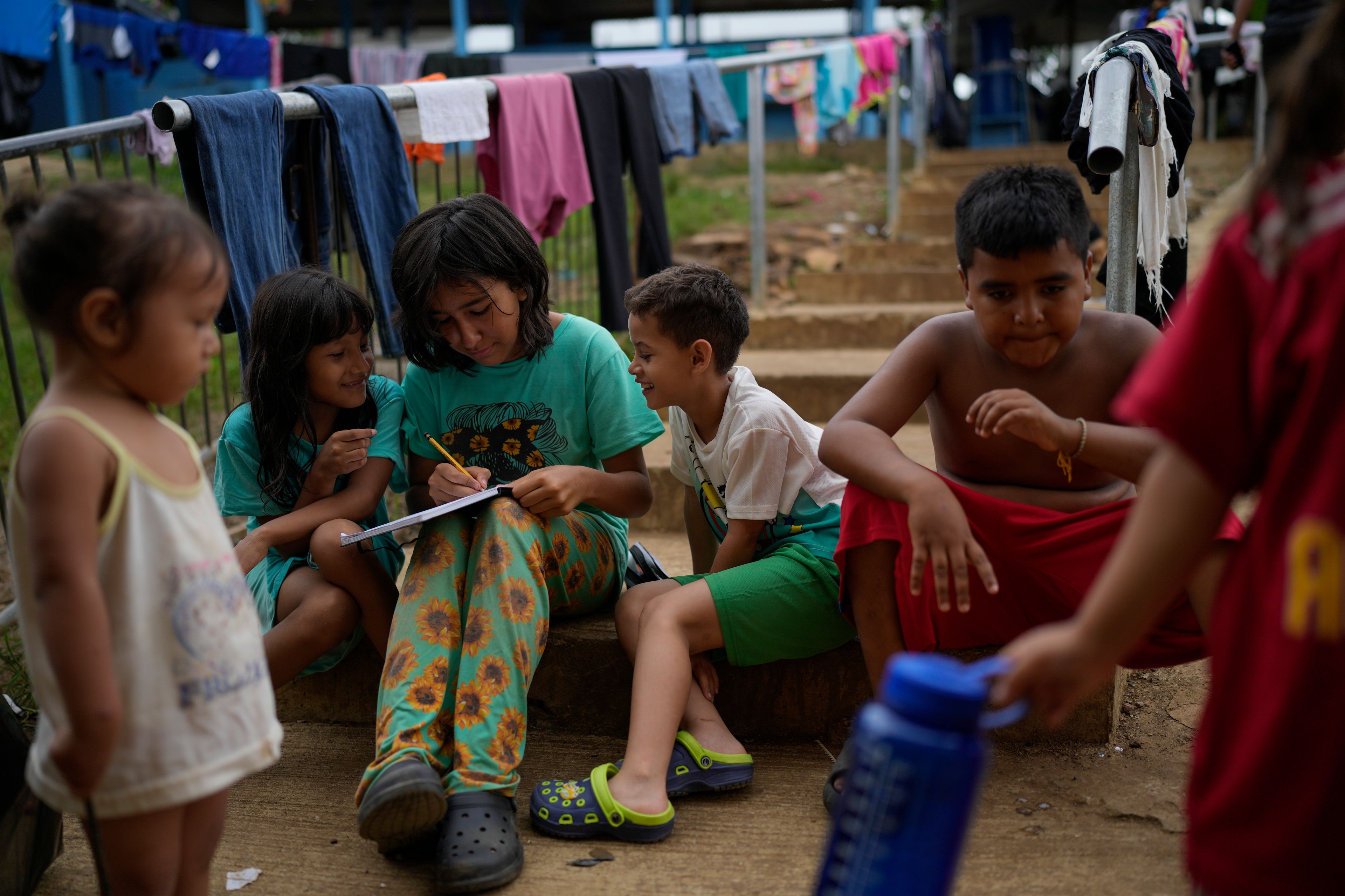 Children play at a camp for migrants in Lajas Blancas, Panama, after walking across the Darien Gap in hopes of reaching the U.S., Thursday, Sept. 26, 2024. (AP Photo/Matias Delacroix)