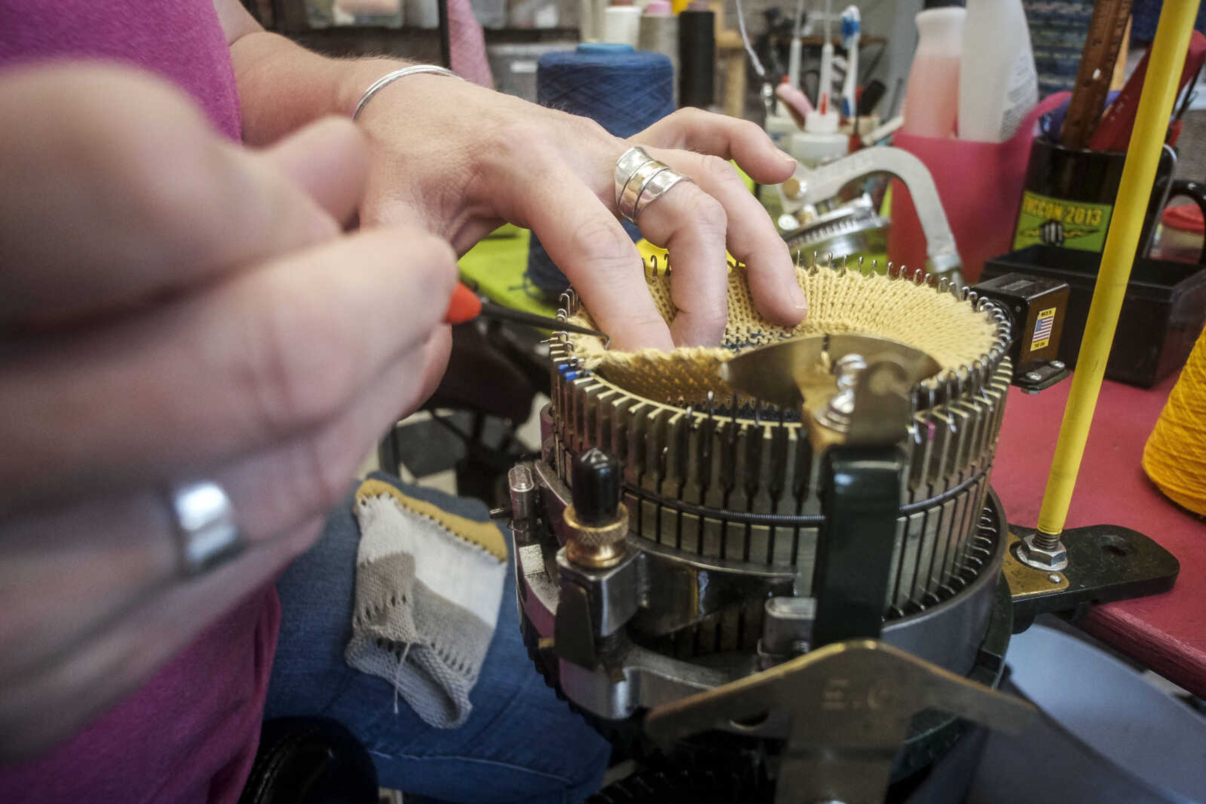 Kim Williams uses an Erlbacher knitting machine to knit a sock.