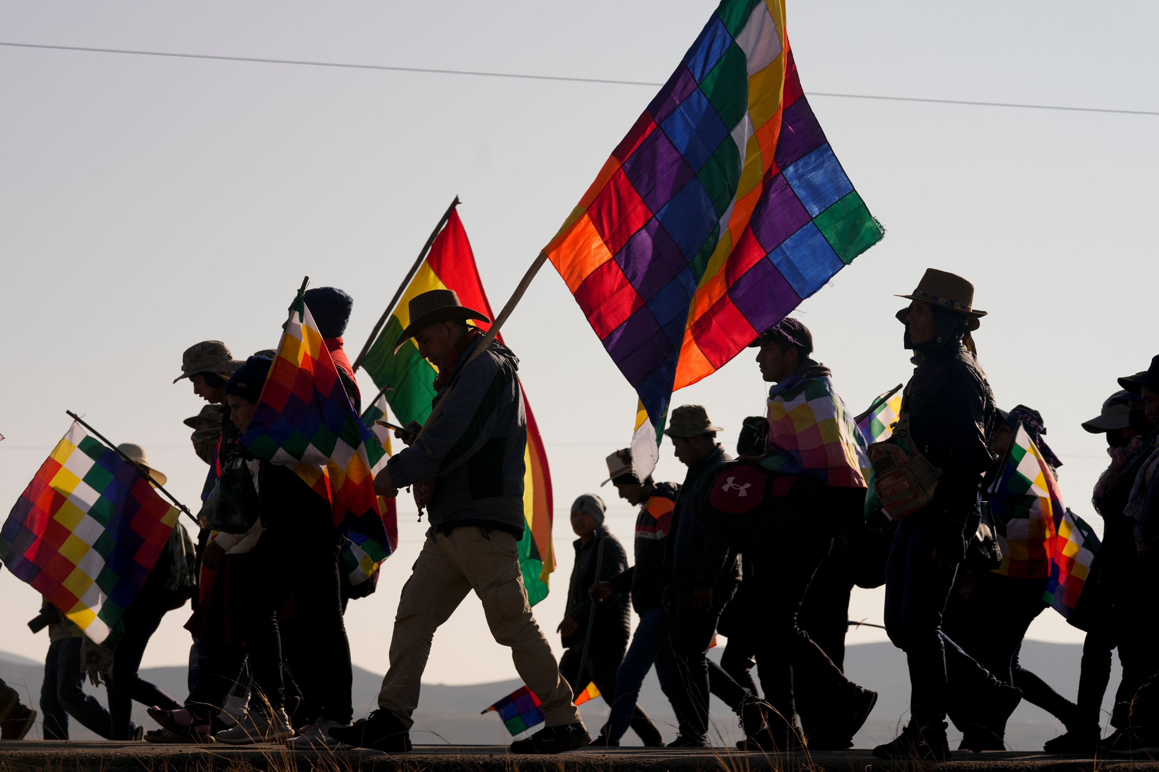 Supporters of former President Evo Morales march to the capital with wiphala flags to protest against the government of President Luis Arce in Panduro, Bolivia, Wednesday, Sept. 18, 2024. (AP Photo/Juan Karita)