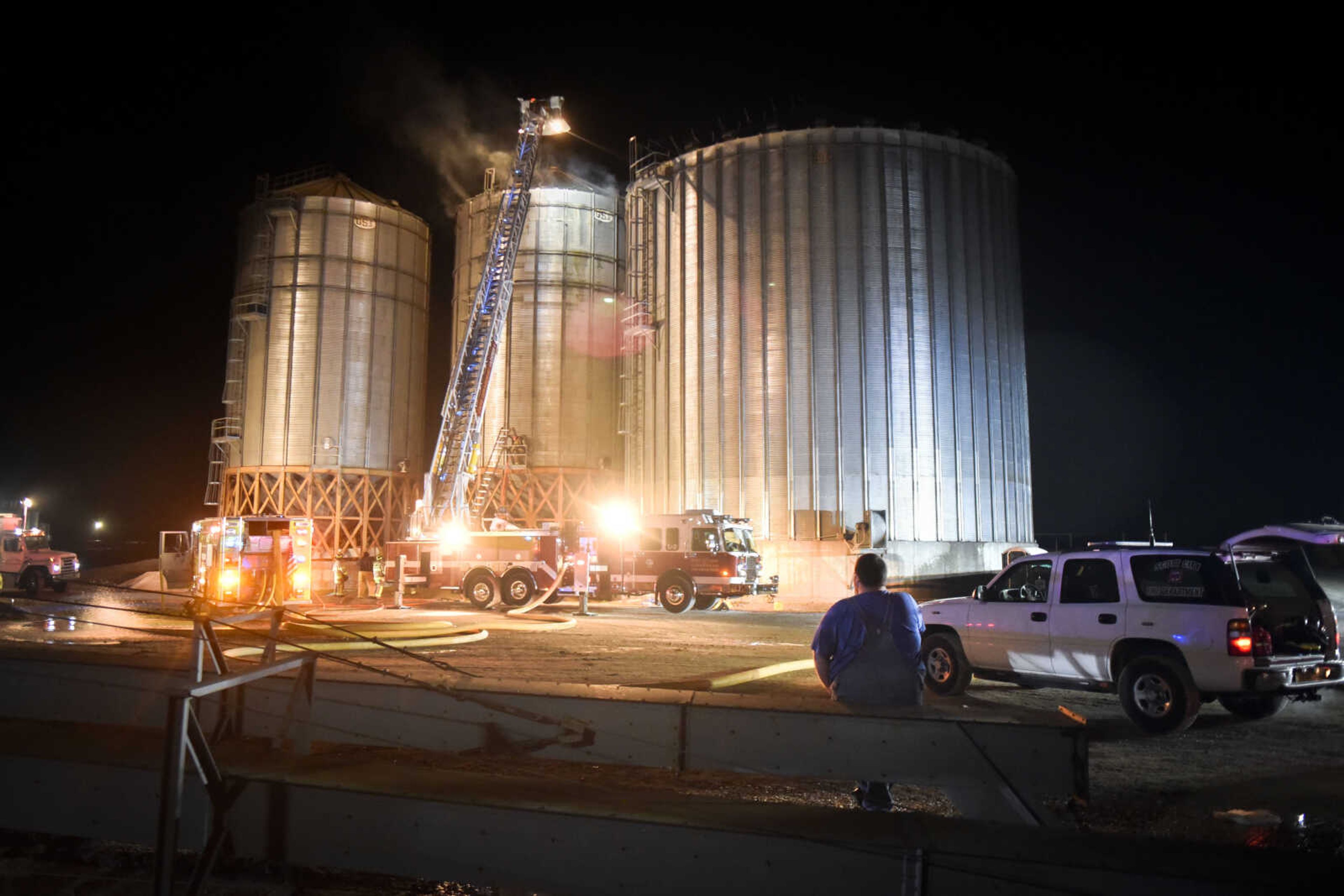 A property manager leans against a railing as local fire departments contain a working fire inside a bin Tuesday at Midwest Grain and Barge in Scott City. No one was injured in the incident, Scott City fire chief Trent August said.