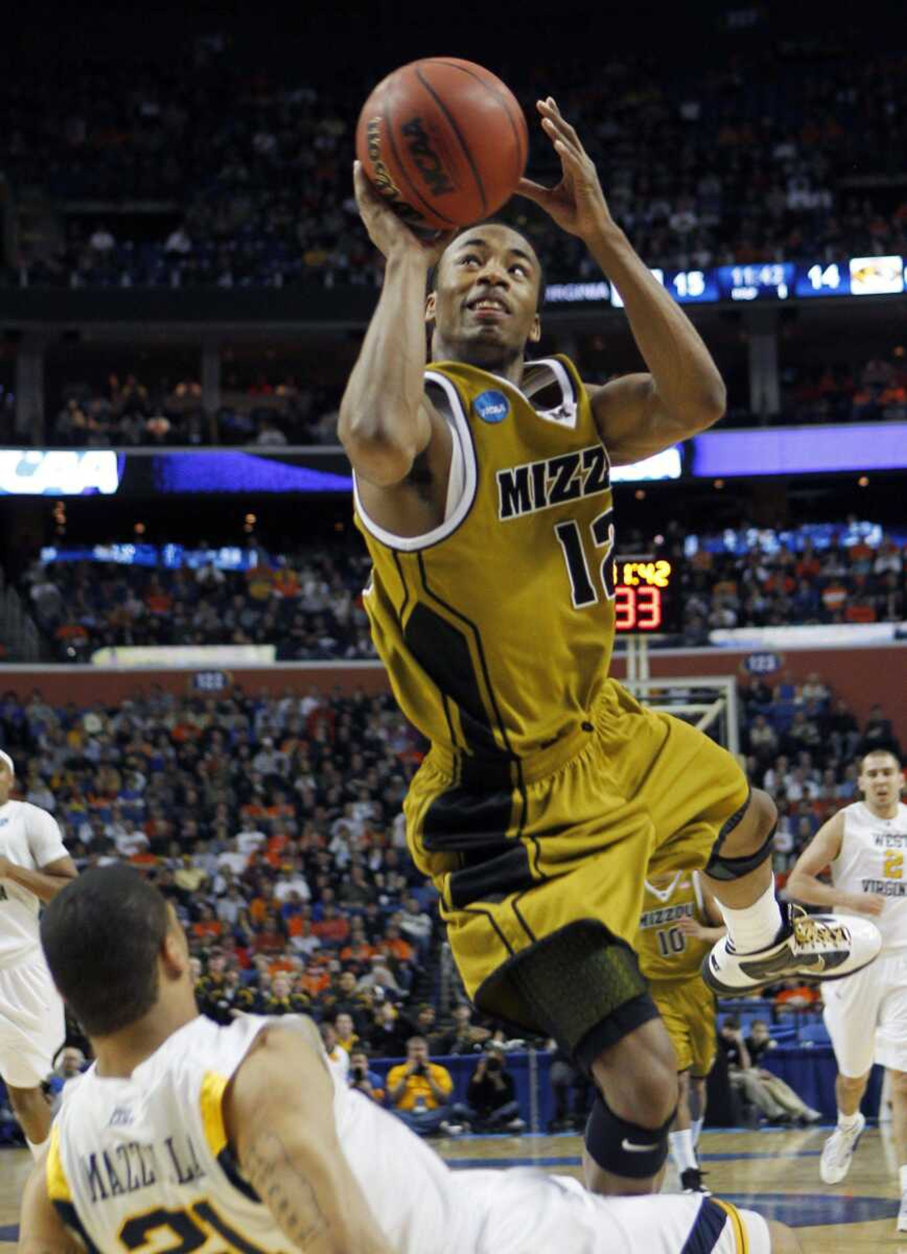 Missouri's Marcus Denmon shoots over West Virginia's Joe Mazzulla during the first half of their game Sunday in Buffalo, N.Y. (DAVID DUPREY ~ Associated Press)