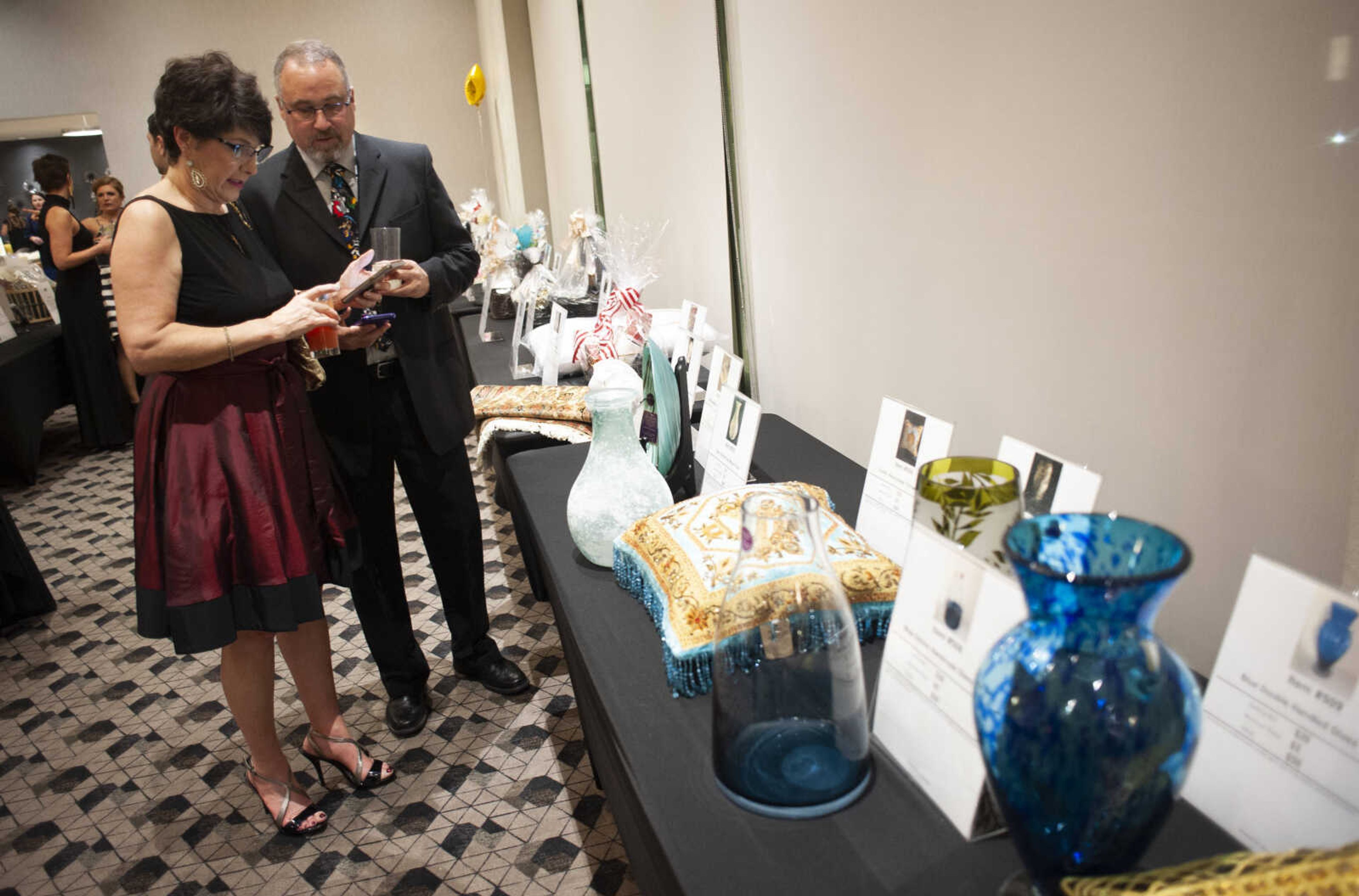 Erica and Paul Hoeflinger of Cape Girardeau look into bidding on items during the 2019 Journey Gala at the Drury Plaza Hotel Conference Center on Saturday, Jan. 19, 2019, in Cape Girardeau. The gala benefits cancer patients at Southeast Cancer Center.