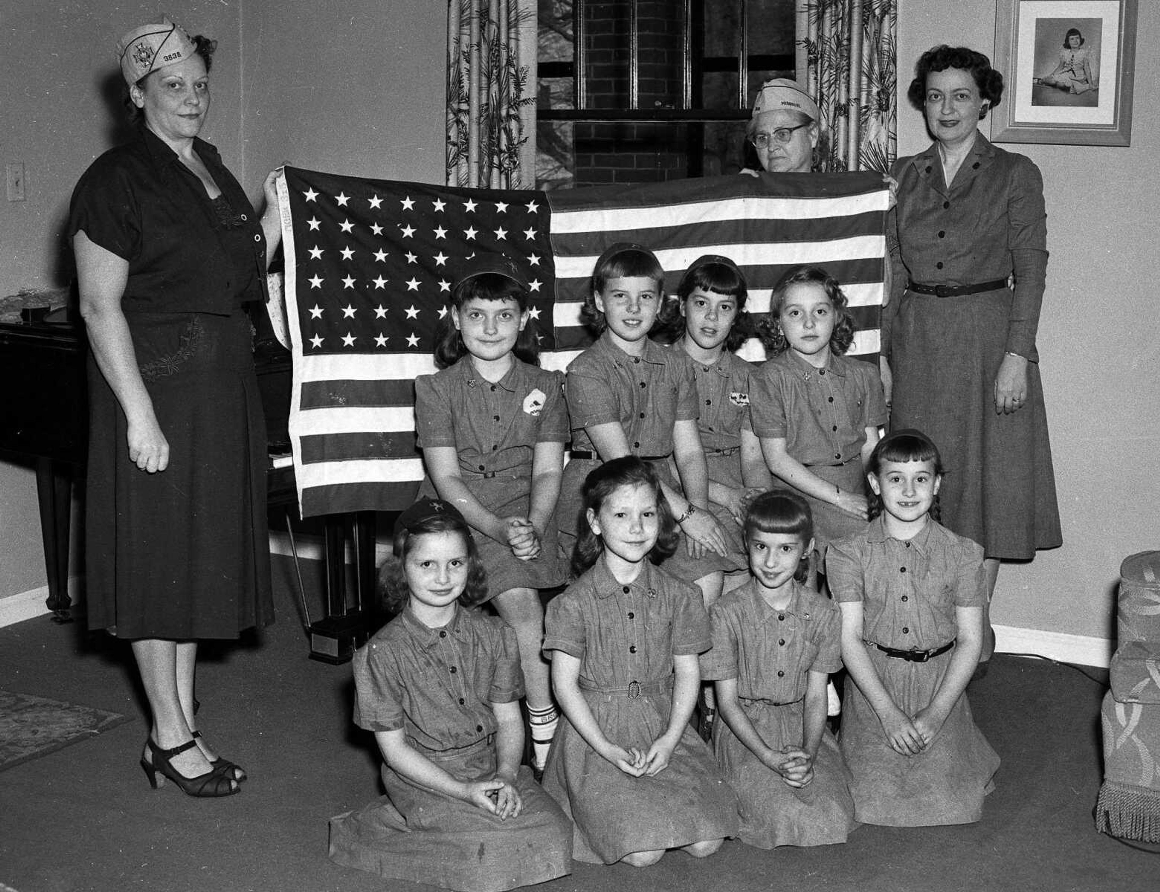 Can you identify any of these patriotic Girl Scouts or their leaders? Ken Steinhoff wrote: "The Brownies may include front row: unknown, Bonnie Strom, Pat Johnson, Patti Haas; back row: Della Dee Heise, Cheri Huckstep, Judy Schrader,
unknown. The woman on the right is Della's mother. I think her name was Della, too." Mary Bradshaw Essner added: "I think the woman on the left looks a lot like Charlene Caldwell... Could possibly be her."