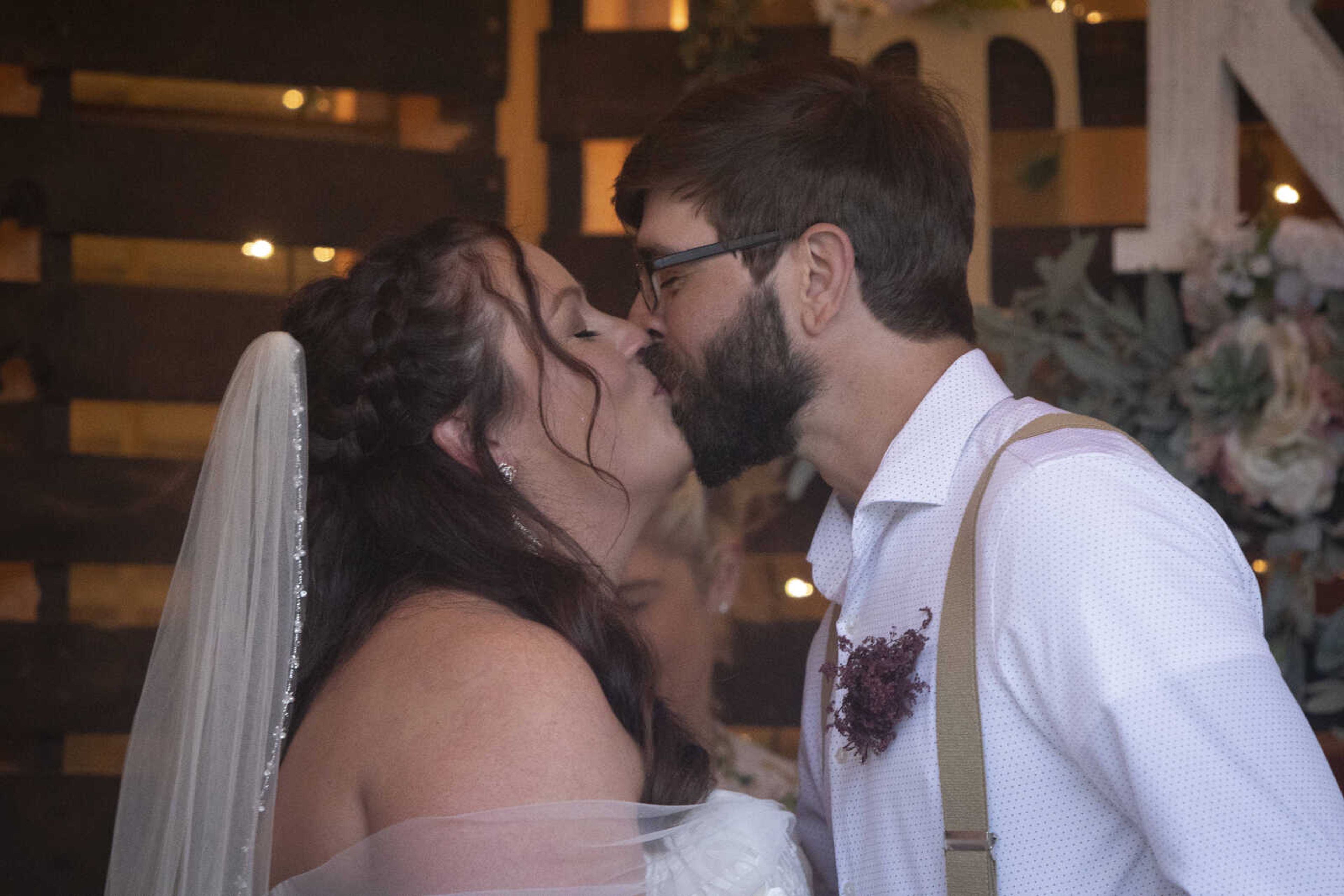 Jenni (Heisserer) Kroenung and Trevor Kroenung kiss during their wedding ceremony Saturday, April 25, 2020, in Scott County, Missouri.