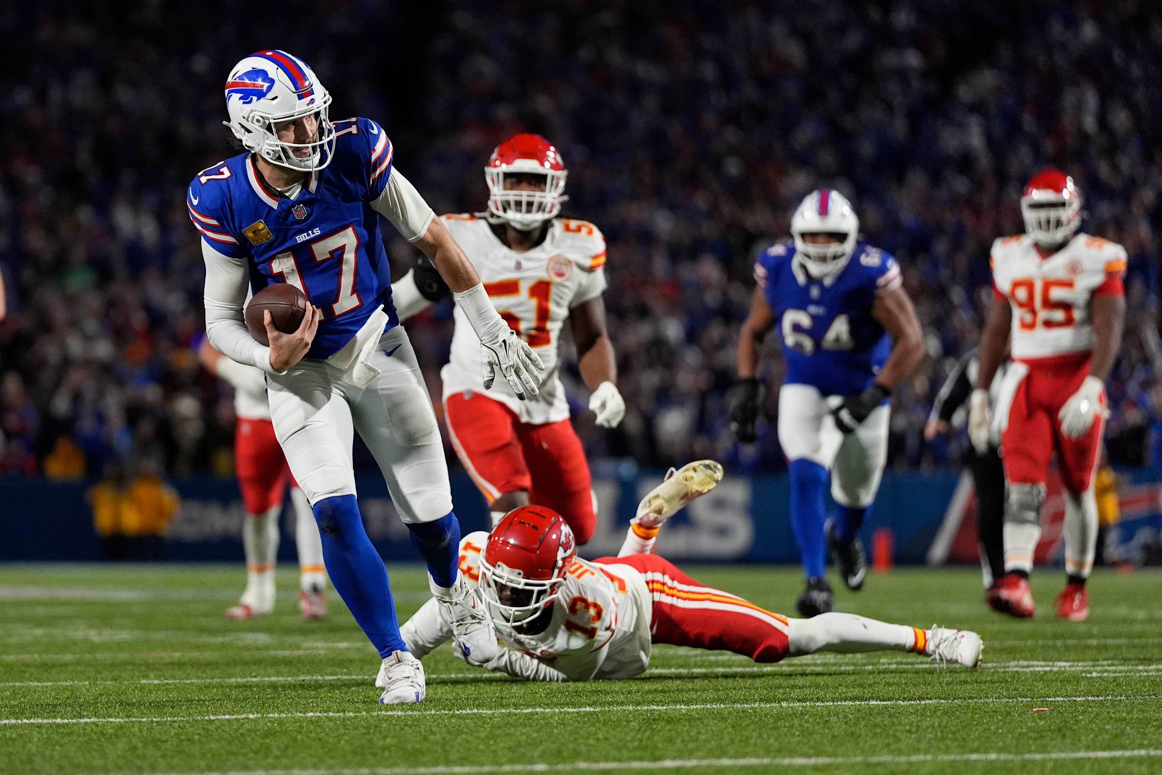 Buffalo Bills quarterback Josh Allen (17) slips past Kansas City Chiefs cornerback Nazeeh Johnson (13) to score on a 26-yard run during the second half of an NFL football game Sunday, Nov. 17, 2024, in Orchard Park, N.Y. (AP Photo/Julia Demaree Nikhinson)