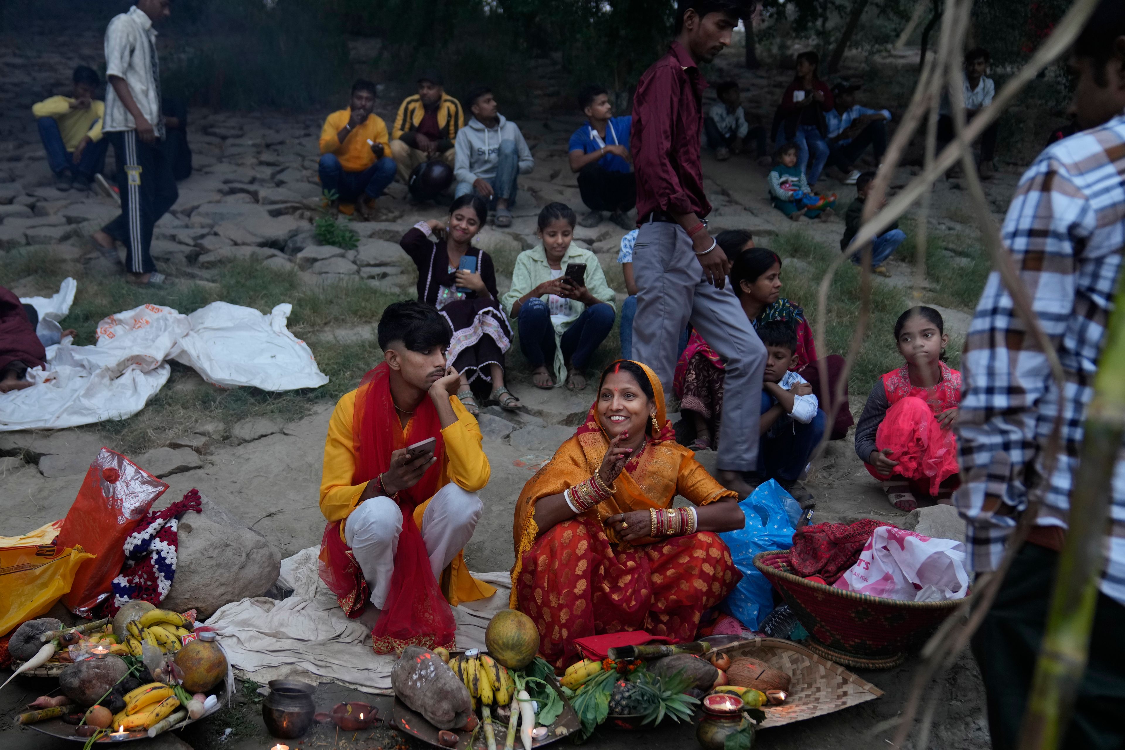 A couple sits with offerings on the banks of the river Yamuna during Chhath festival in Noida, near New Delhi, India, Friday, Nov. 8, 2024. (AP Photo/Manish Swarup)