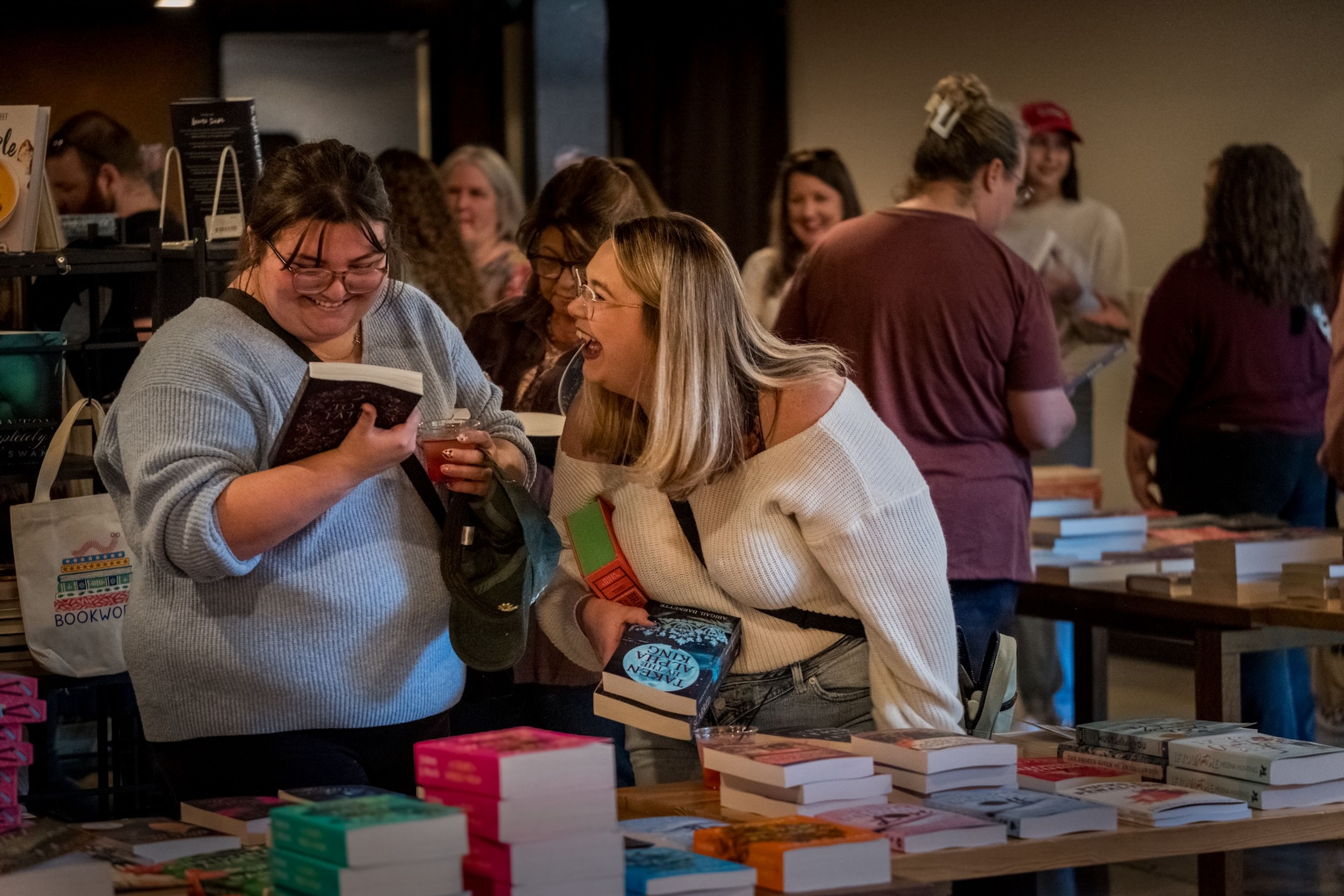 Abigail Whitehead and Cassidy Holman, both from Advance enjoy refreshments and laughter as they browse books inspired by their love for the "Bridgerton" series.
