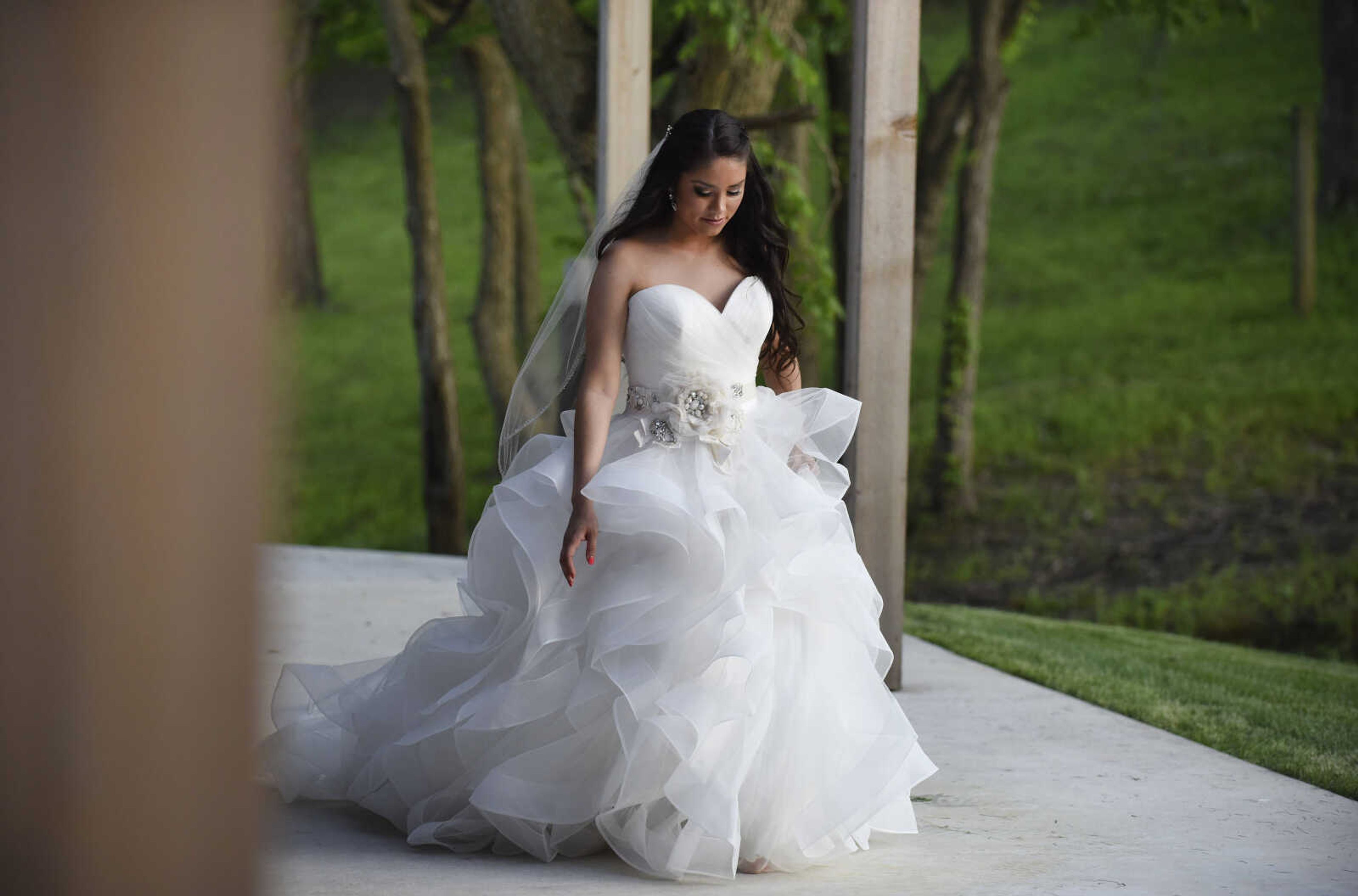 Allure Bridals strapless horsehair gown with flower belt from Enzoani, veil from Giselle Bridal and Jim Ball earrings. Available at Joy's Bridal in Sikeston, Missouri.