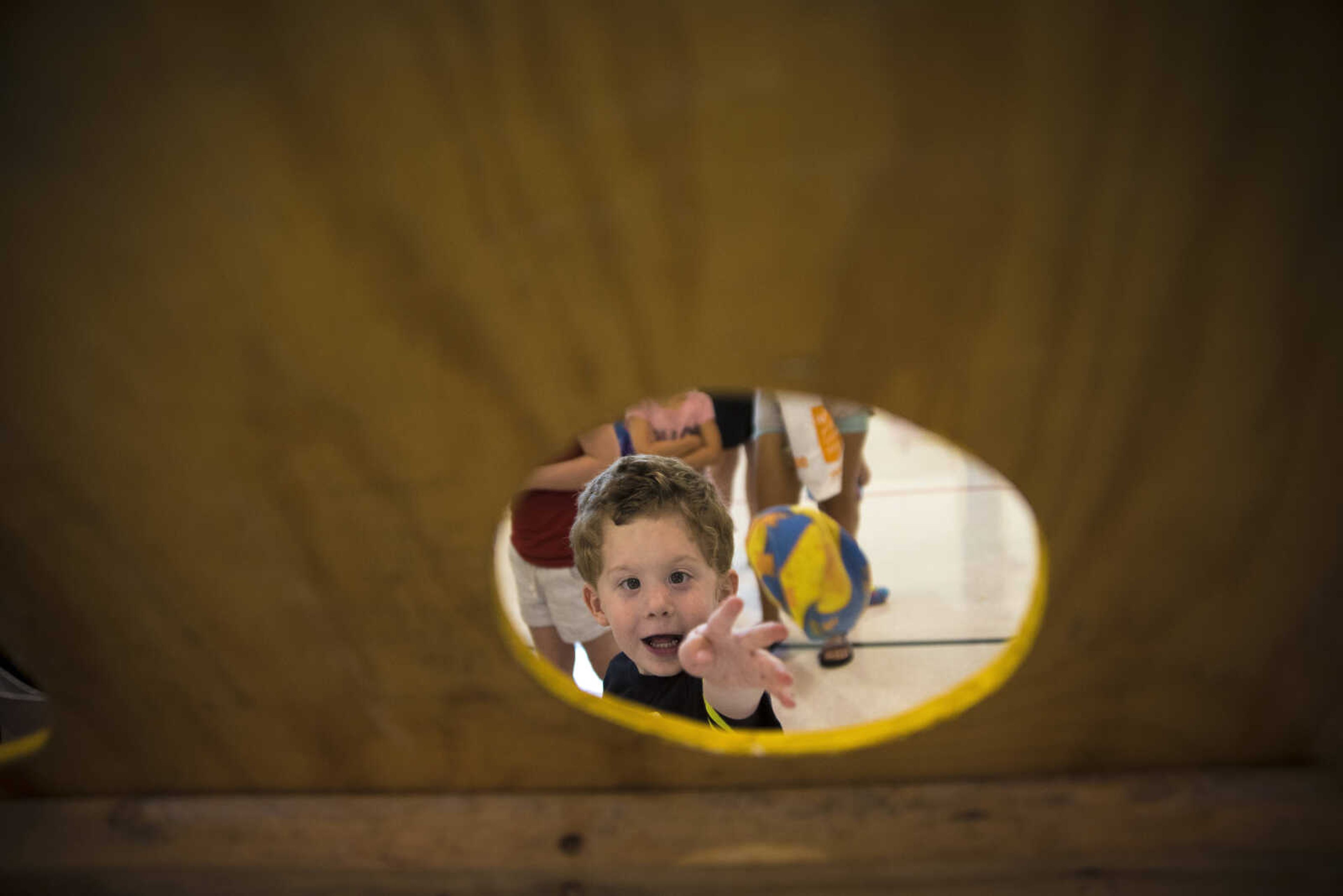 Carson Cooley, 3, tosses a bean bag through a hole during the Parks and Rec Day Friday, July 7, 2017 at the Osage Centre in Cape Girardeau.