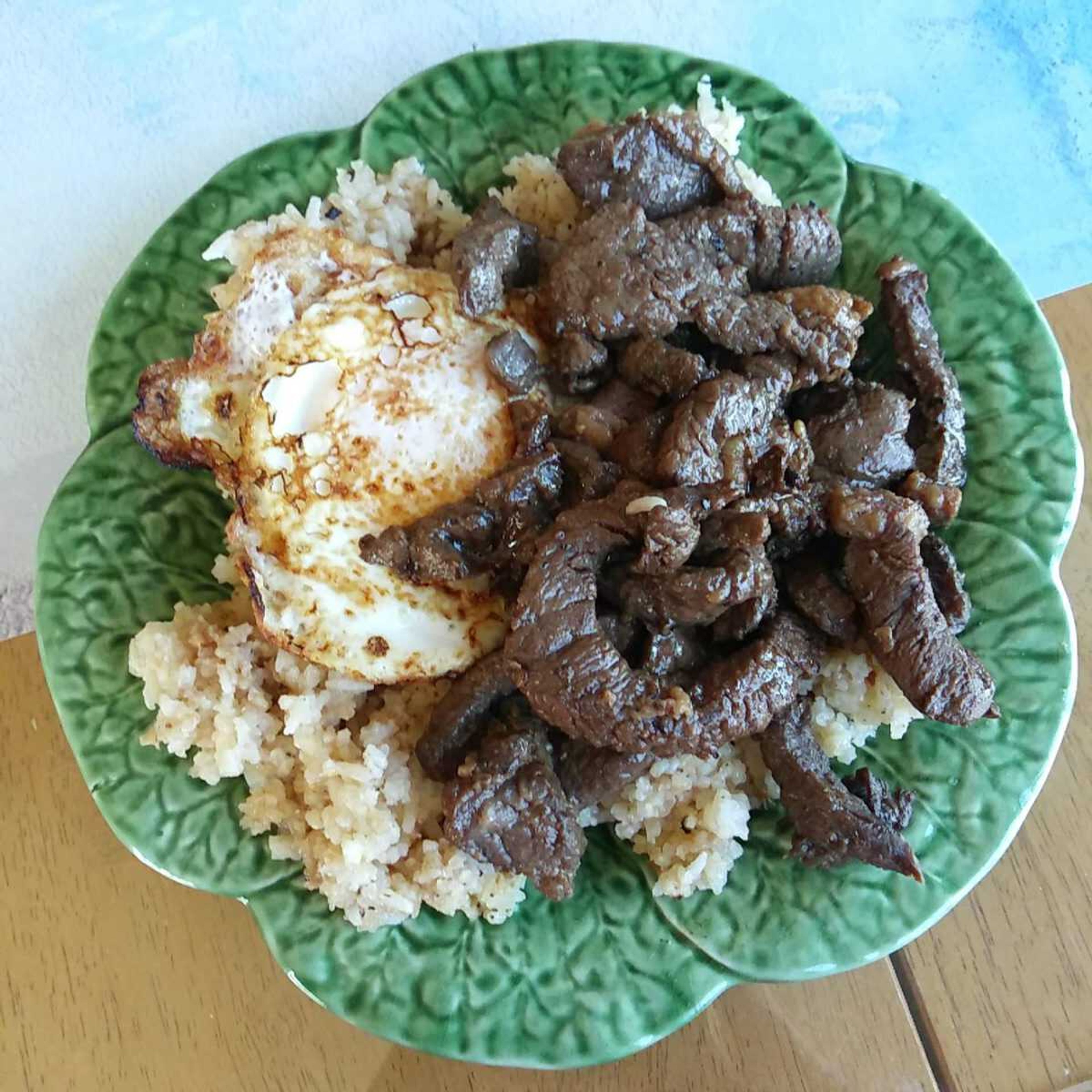 Tapsilog, a wonderful garlic fried rice bowl with strips of sirloin and a fried egg.