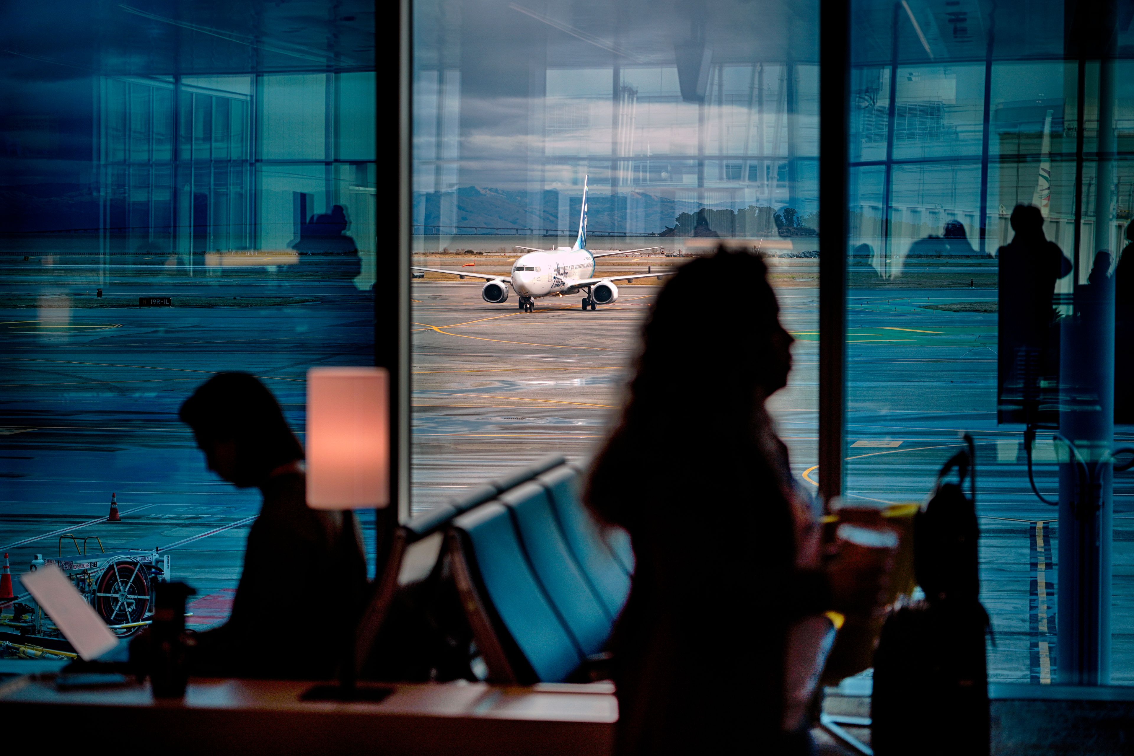 A passenger plane taxies on a water-soaked runway at San Francisco Airport while passengers wait for flights on Thursday, Nov. 21, 2024, in San Francisco. (AP Photo/Andy Bao)