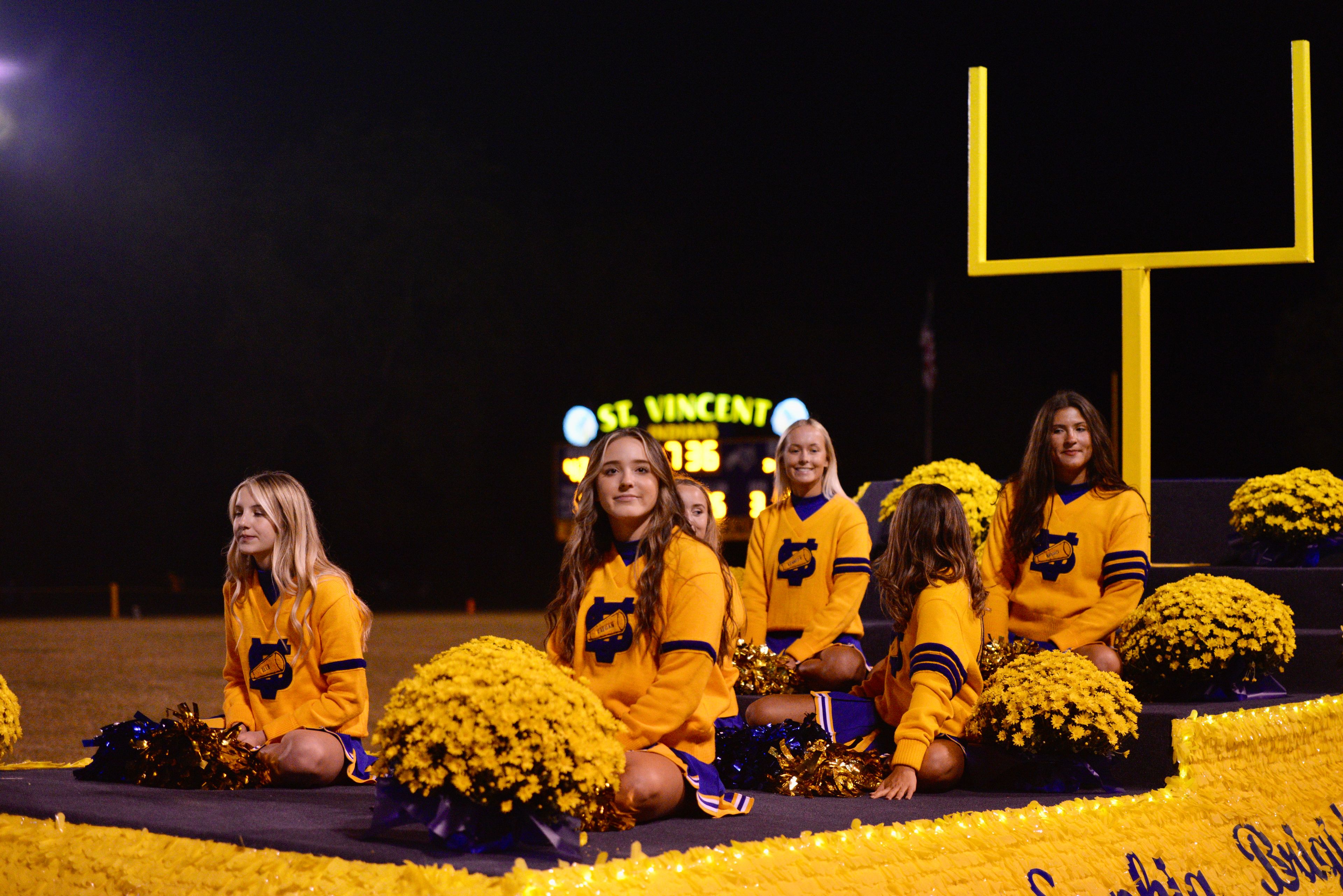 St. Vincent cheerleaders ride a homecoming float during halftime of a game against Cuba on Friday, Oct. 11, in Perryville. 