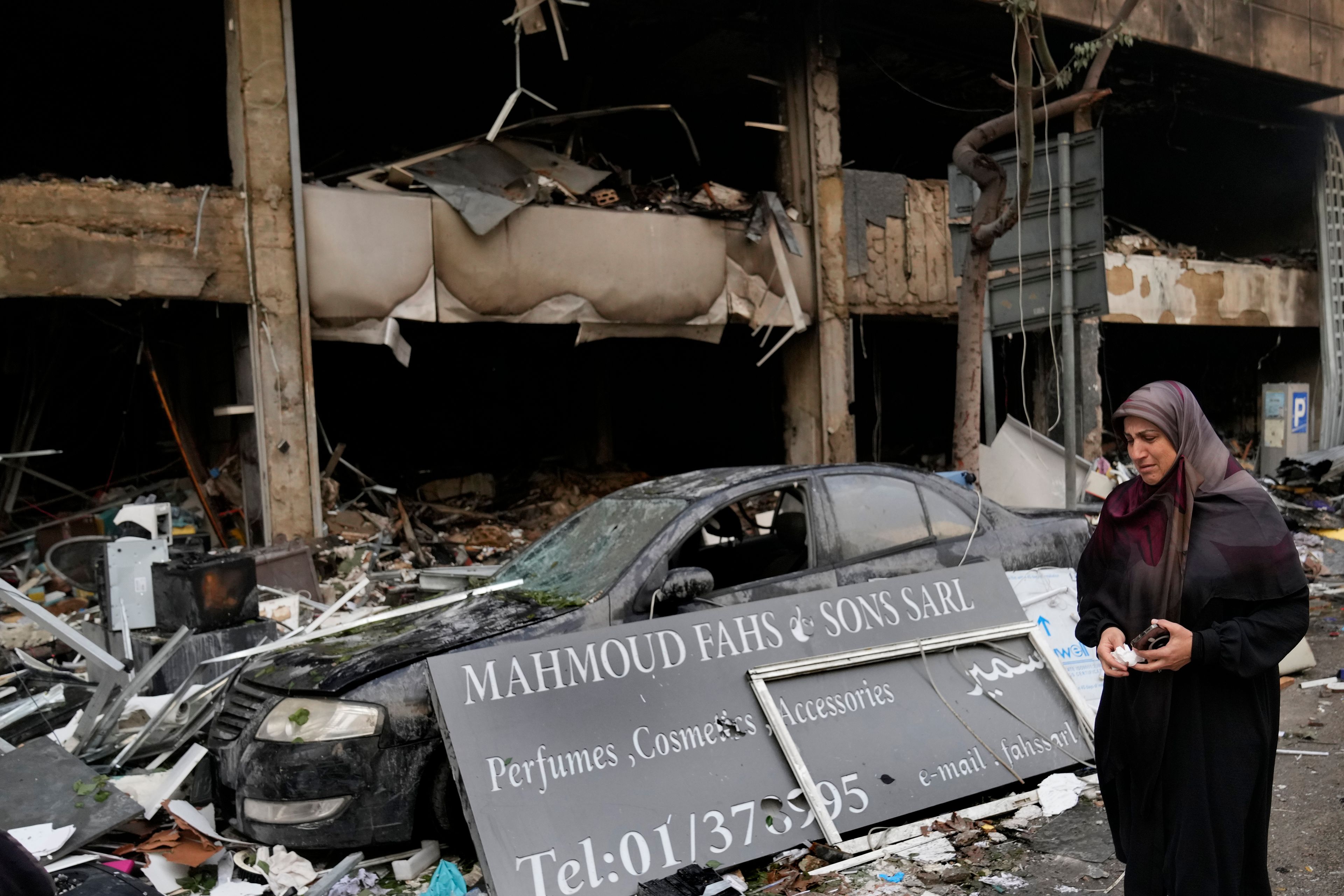 A woman weeps as she passes in front of destroyed shops that were hit Sunday evening in an Israeli airstrike in central Beirut, Lebanon, Monday, Nov. 18, 2024. (AP Photo/Hussein Malla)