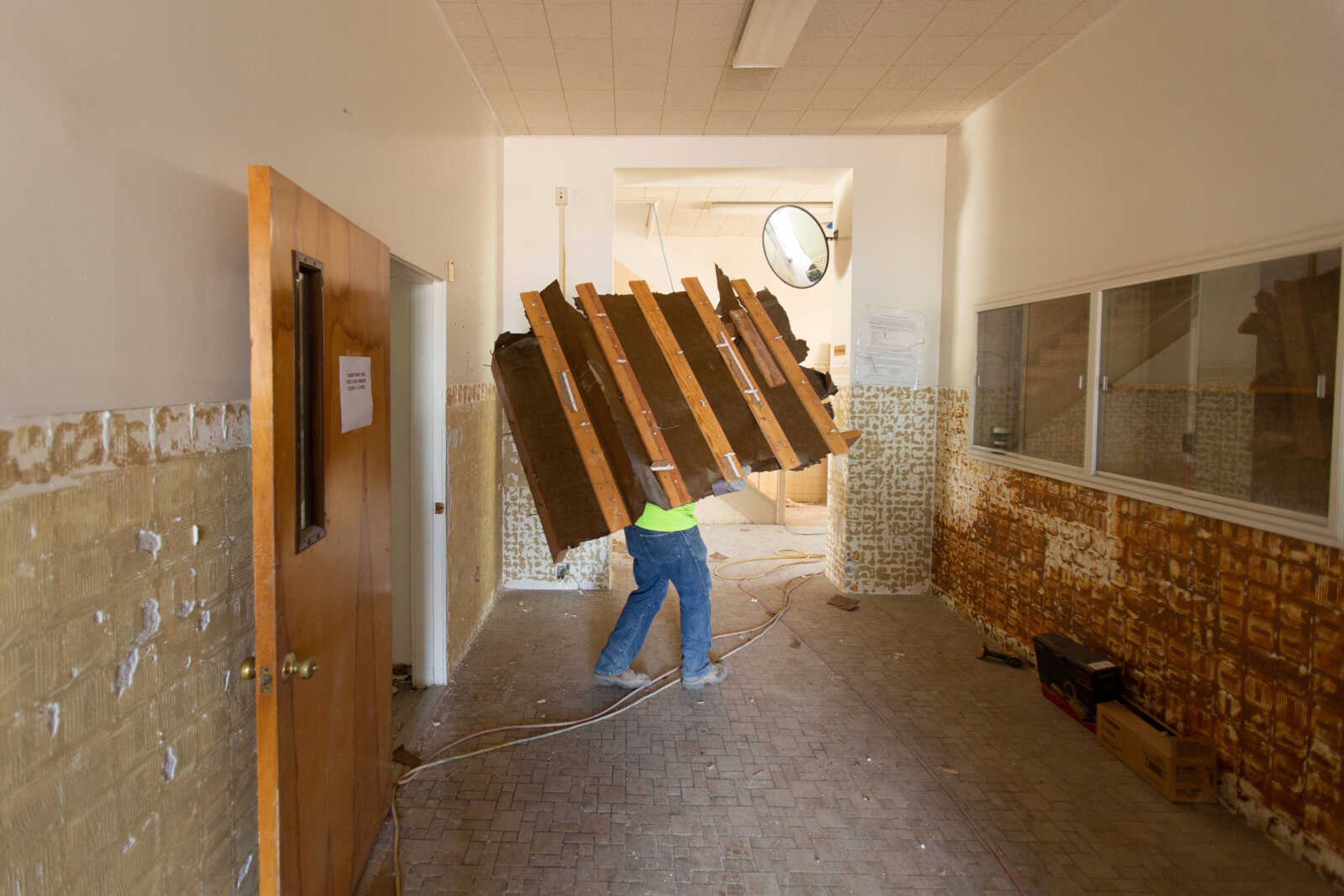 A portion of paneling and wood strips is carried through the hall as crews from Penzel Construction continue the demolition phase of the Common Pleas Courthouse renovation on Tuesday, June 16, 2020.