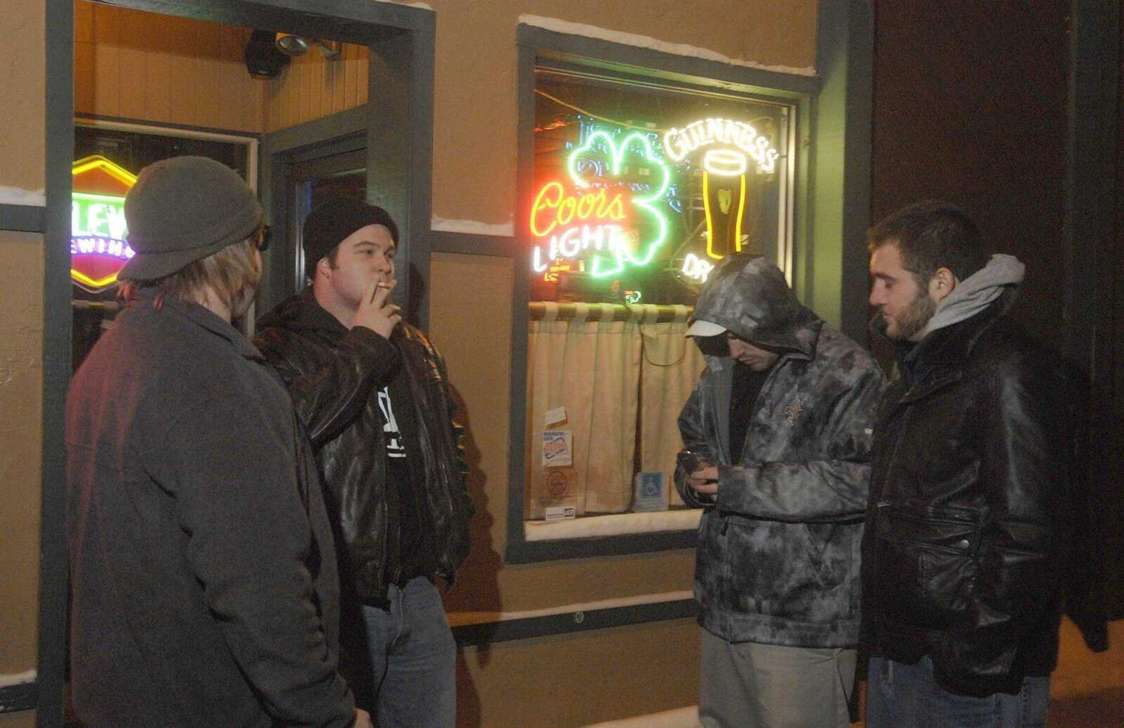 From left, Chris Masters, Levi Herborn, Brian Brock and Andrew Garcia smoke in front of McNally's bar in Columbia, Mo. on Tuesday Jan. 11, 2011. The City of Columbia enacted a city ordinance to ban smoking in Columbia restaurants and bars in January 2007. (DON SHRUBSHELL)