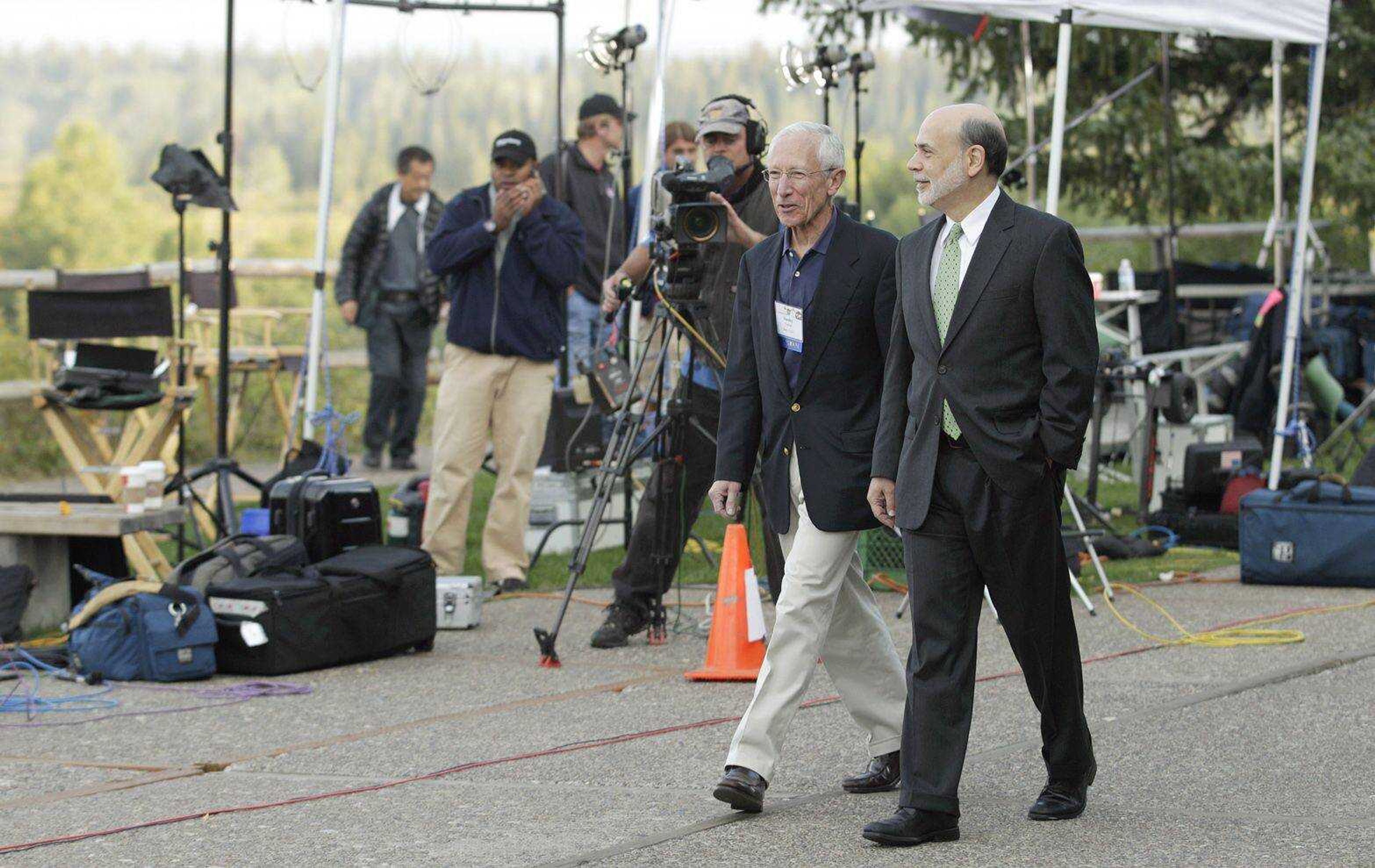 Federal Reserve chairman Ben Bernanke, right, and Bank of Israel governor Stanley Fischer walk together past television cameras Friday outside of the Jackson Hole Economic Symposium at Grand Teton National Park near Jackson Hole, Wyo. Bernanke made clear Friday that the Federal Reserve will do more to boost the economy because of high U.S. unemployment and an economic recovery that remains "far from satisfactory." (Ted S. Warren ~ Associated Press)