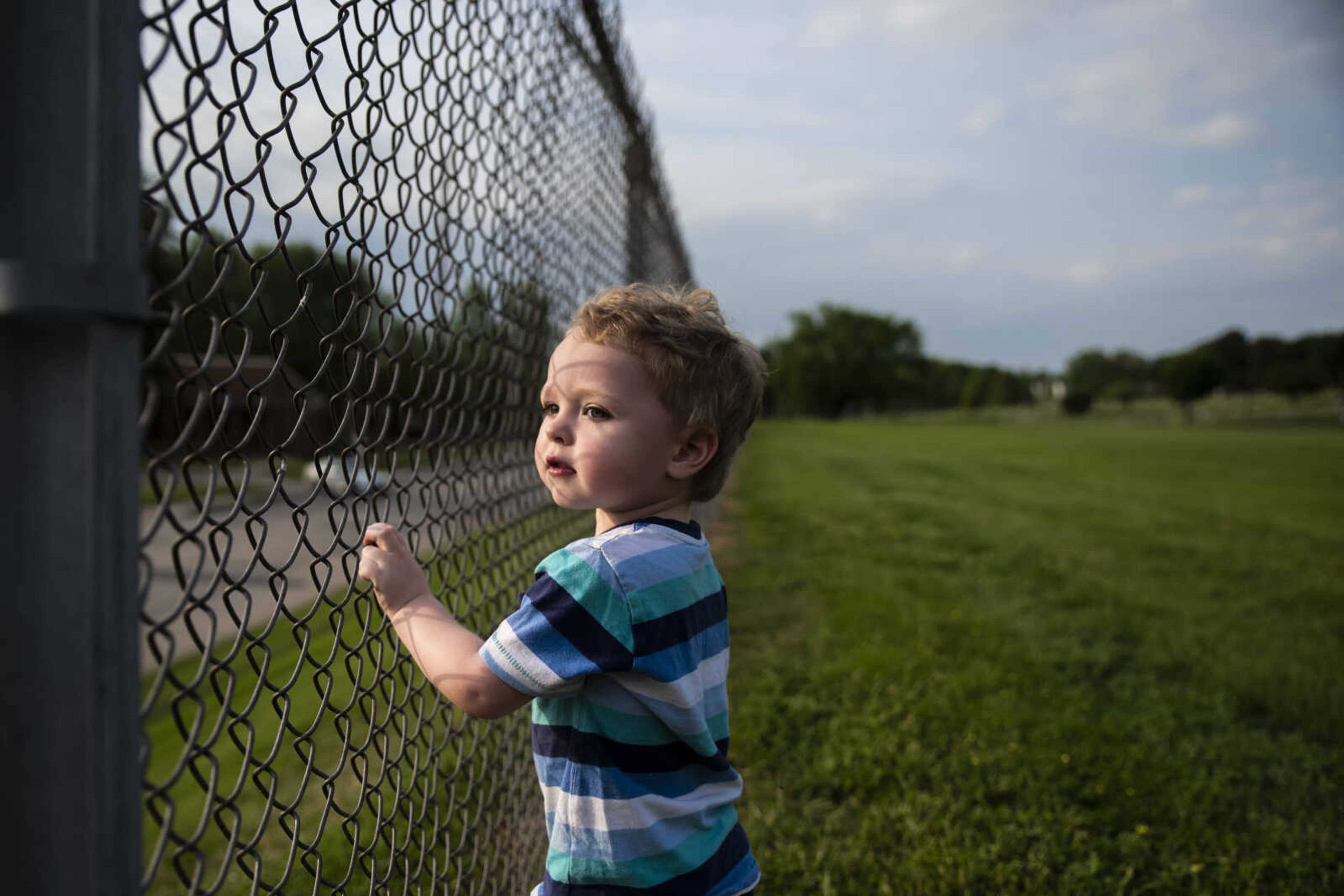 Phoenix Young, 2, watches cars drive by from a fence in a field behind his house Tuesday, May 7, 2019, in Cape Girardeau.