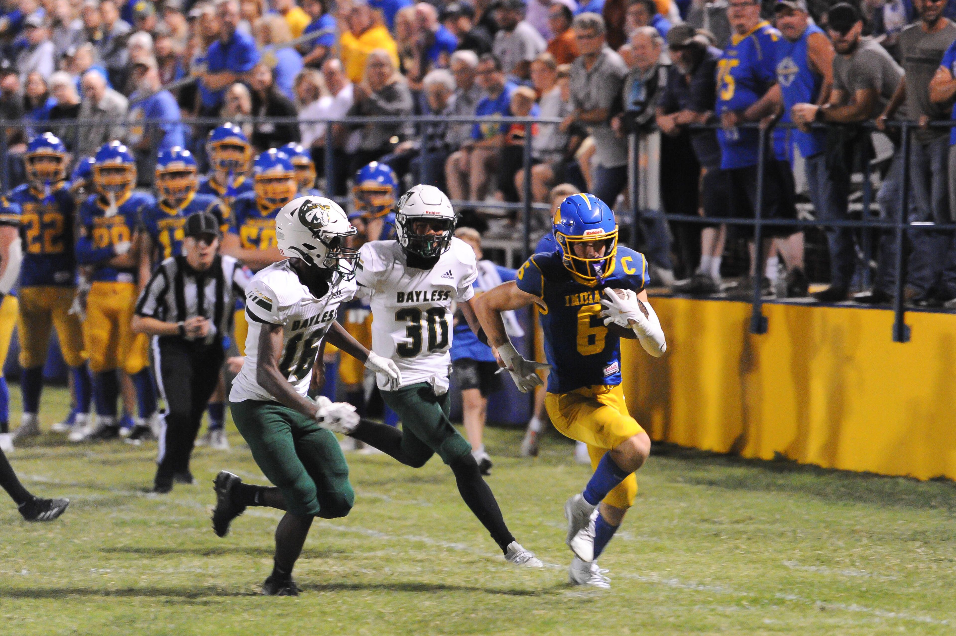 St. Vincent’s Clayton Gremaud, right, takes off down the sideline during a game between the St. Vincent Indians and the Bayless Bronchos on Friday, Oct. 4, at St. Vincent High School in Perryville. 