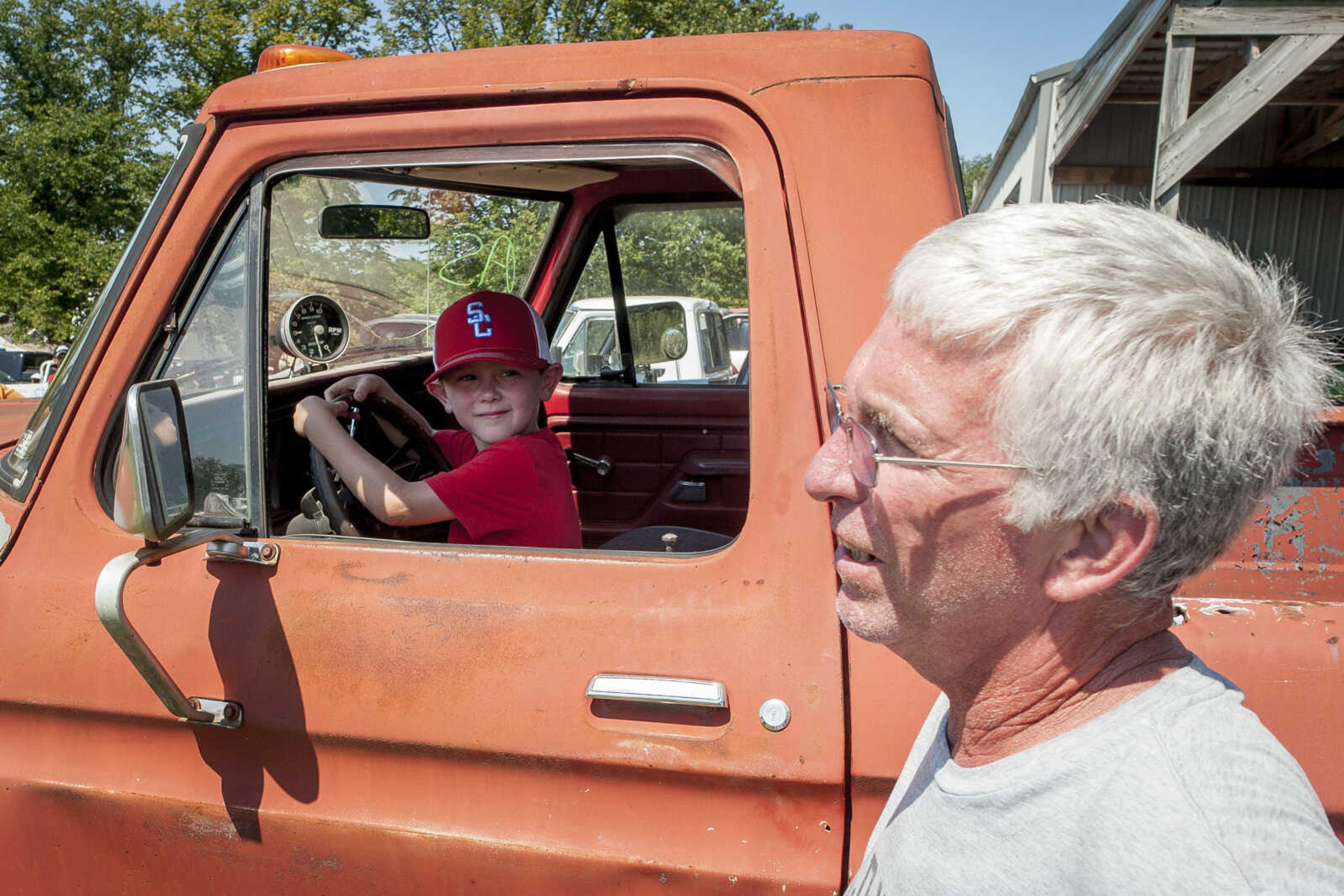 Drew Benson, 6, glances at his grandfather, Rodney, while playing in Rodney's mud-racing truck before the annual mud races during Benton Neighbor Days  Saturday, Aug. 31, 2019 in Benton.