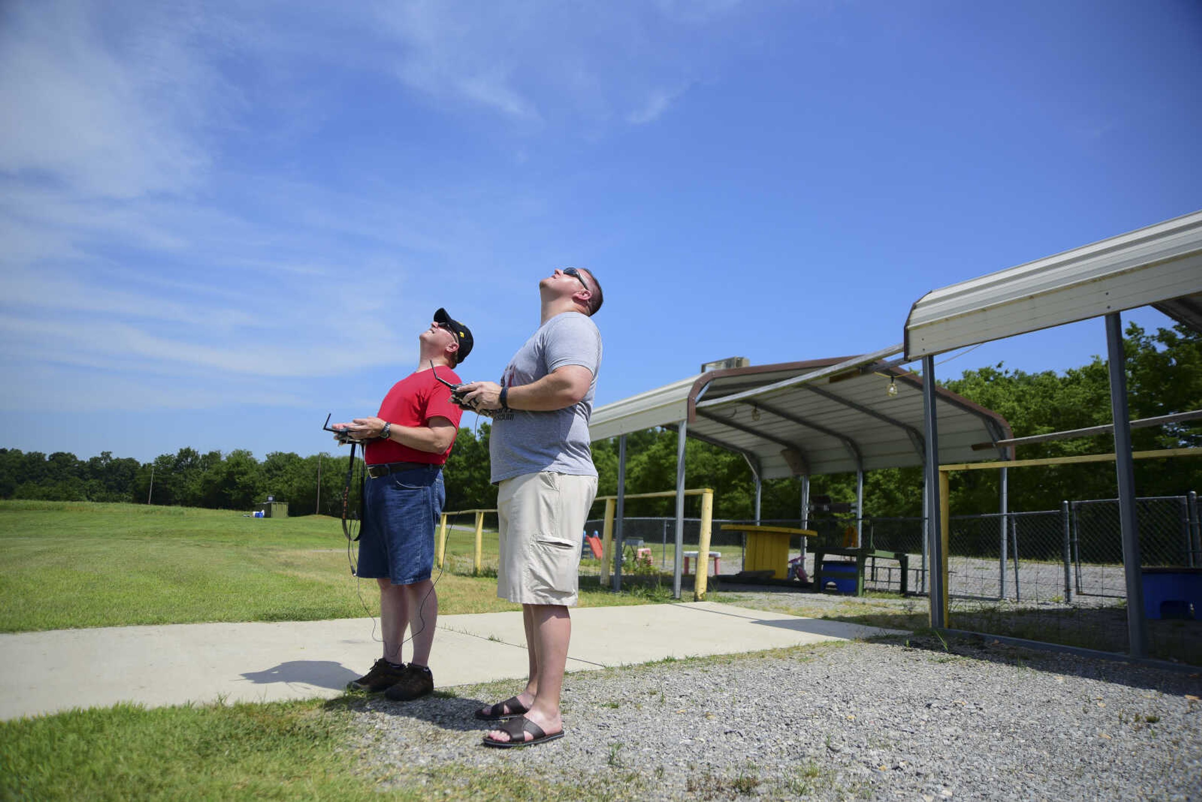 Mark McCoy, left, shows Ben Blake, right, how to fly a model airplane for the Cape Fly Hi radio controlled aircraft demonstration Saturday, June 3, 2017 at Galaxy Park in Cape Girardeau.