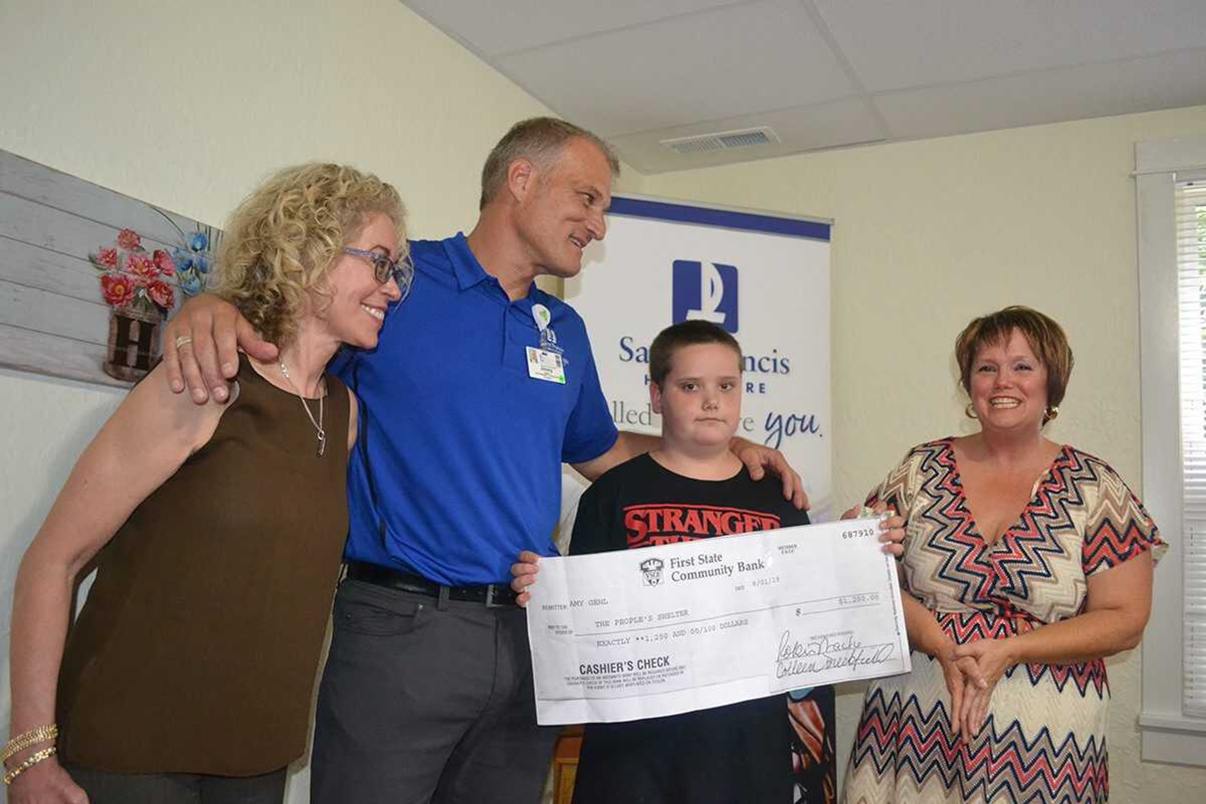 Jacob Abernathy, 10, of Fruitland, presented a check for $1,250 that he raised selling lemonade to benefit The Peaceful Place - Saint Francis House, a new residence for homeless men age 50 and older at 827 Jefferson St. during a "house warming" Aug. 7. With him are, from left, Saint Francis Healthcare System and CEO Maryann Reese, vice president of marketing and the Saint Francis Foundation Jimmy Wilferth, and Rev. Renita Green of The People's Shelter.