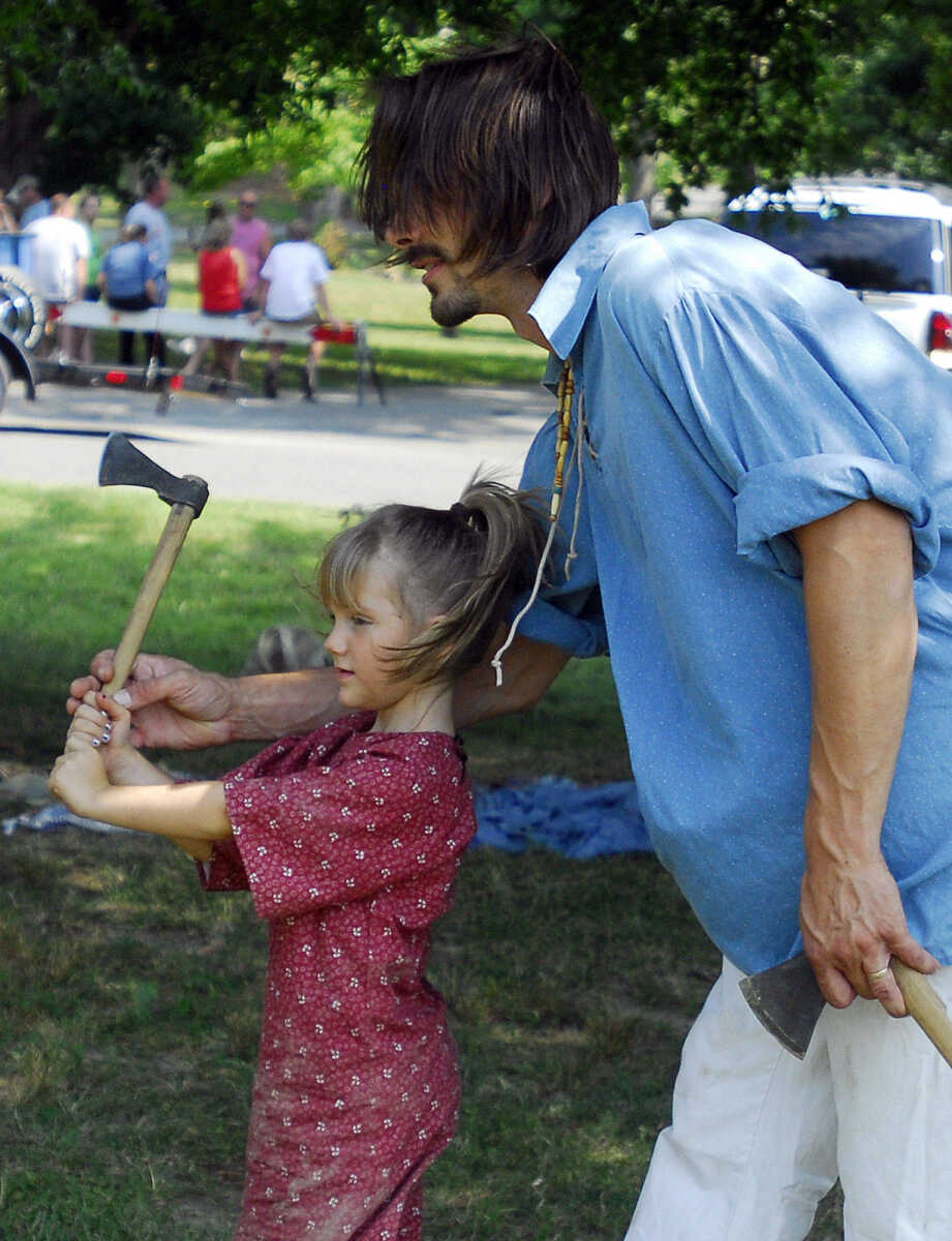 LAURA SIMON~lsimon@semissourian.com
Mac Armbruster teaches his daughter Mackinze to throw a tomahawk outside the 1700's village during Jackson's Fourth of July festivities Sunday in Jackson City Park.