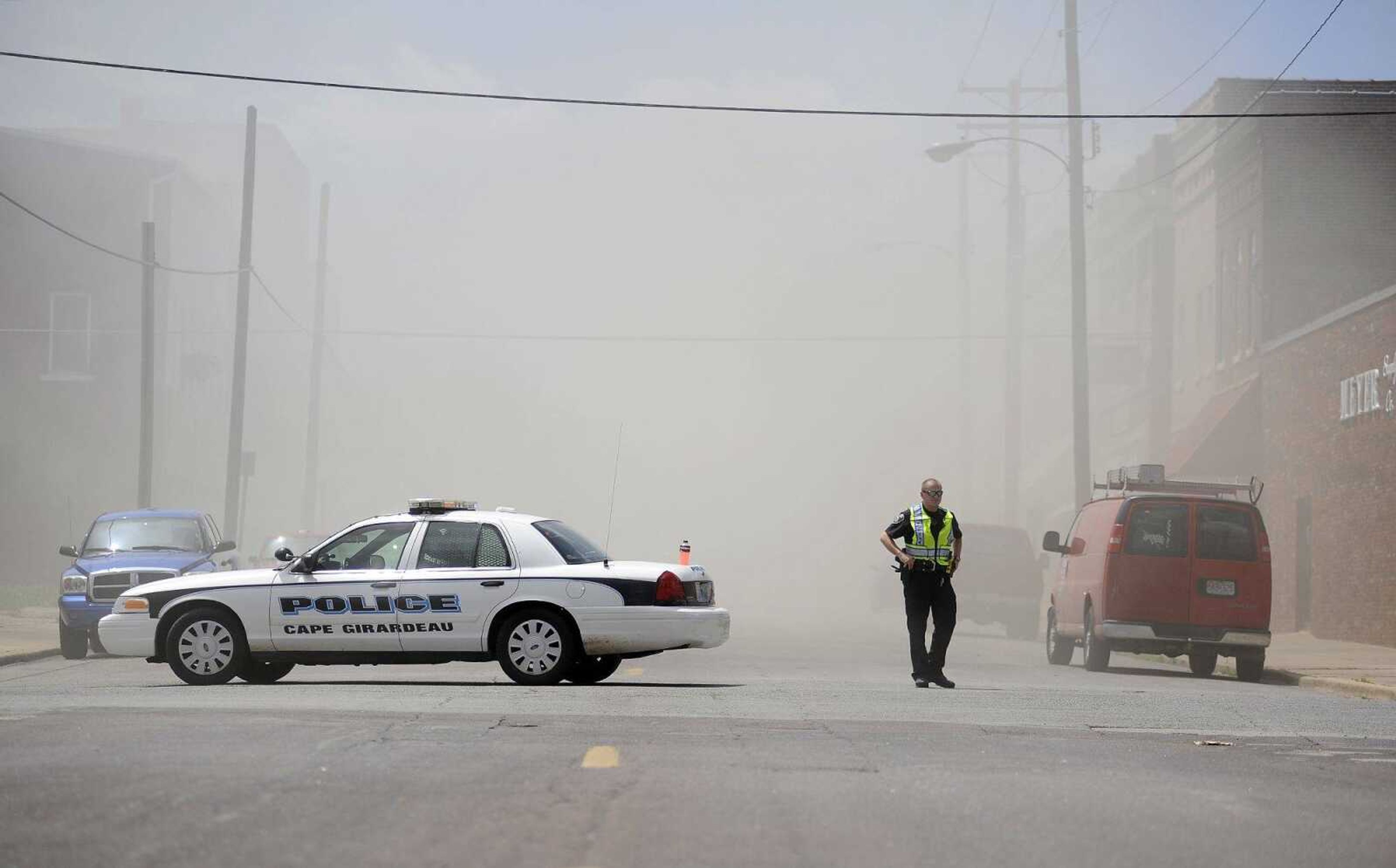 Heavy smoke obscures the background as a member of the Cape Girardeau Police Department stands guard at the intersection of Good Hope and South Frederick Street as firefighters battle a blaze in a structure at 238 S. Sprigg St. on Tuesday afternoon. Portions of S. Sprigg and Good Hope Streets are closed as crews work the scene.
