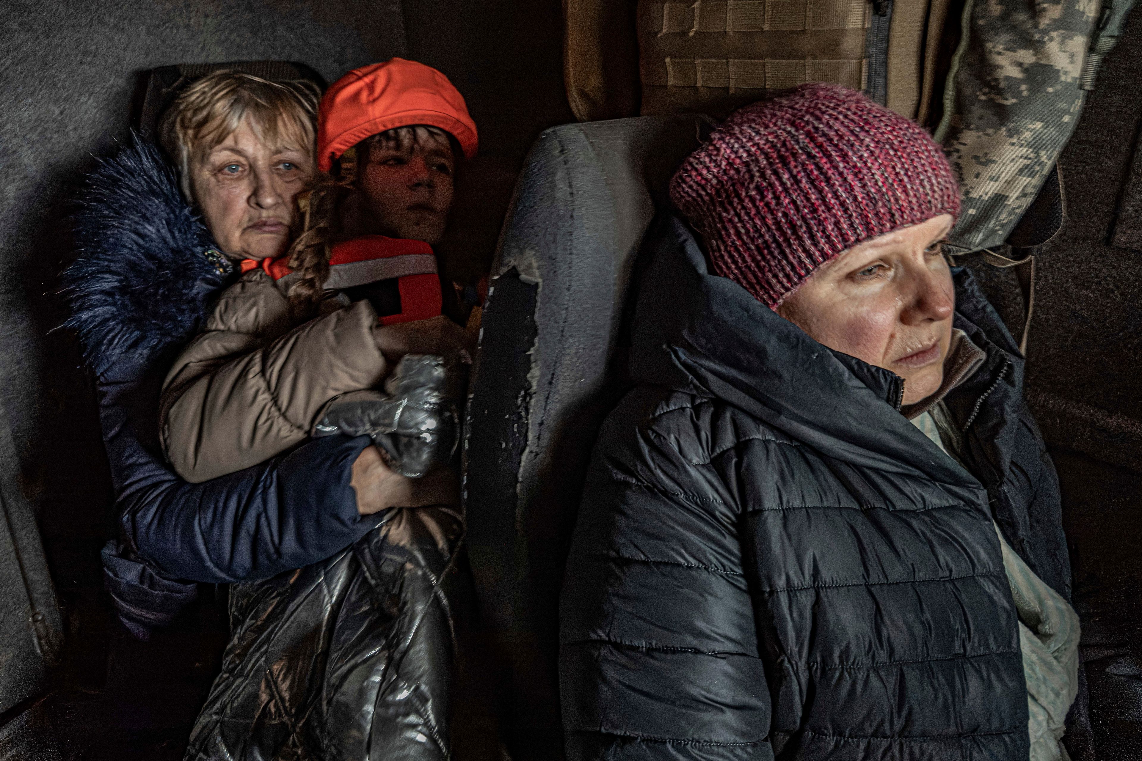 Katia, 11, with her grandmother and mother sit in an armored minivan during en evacuation by the "White Angels" police unit in Kurakhove, Donetsk region, Ukraine, on Nov. 4, 2024. (AP Photo/Anton Shtuka)